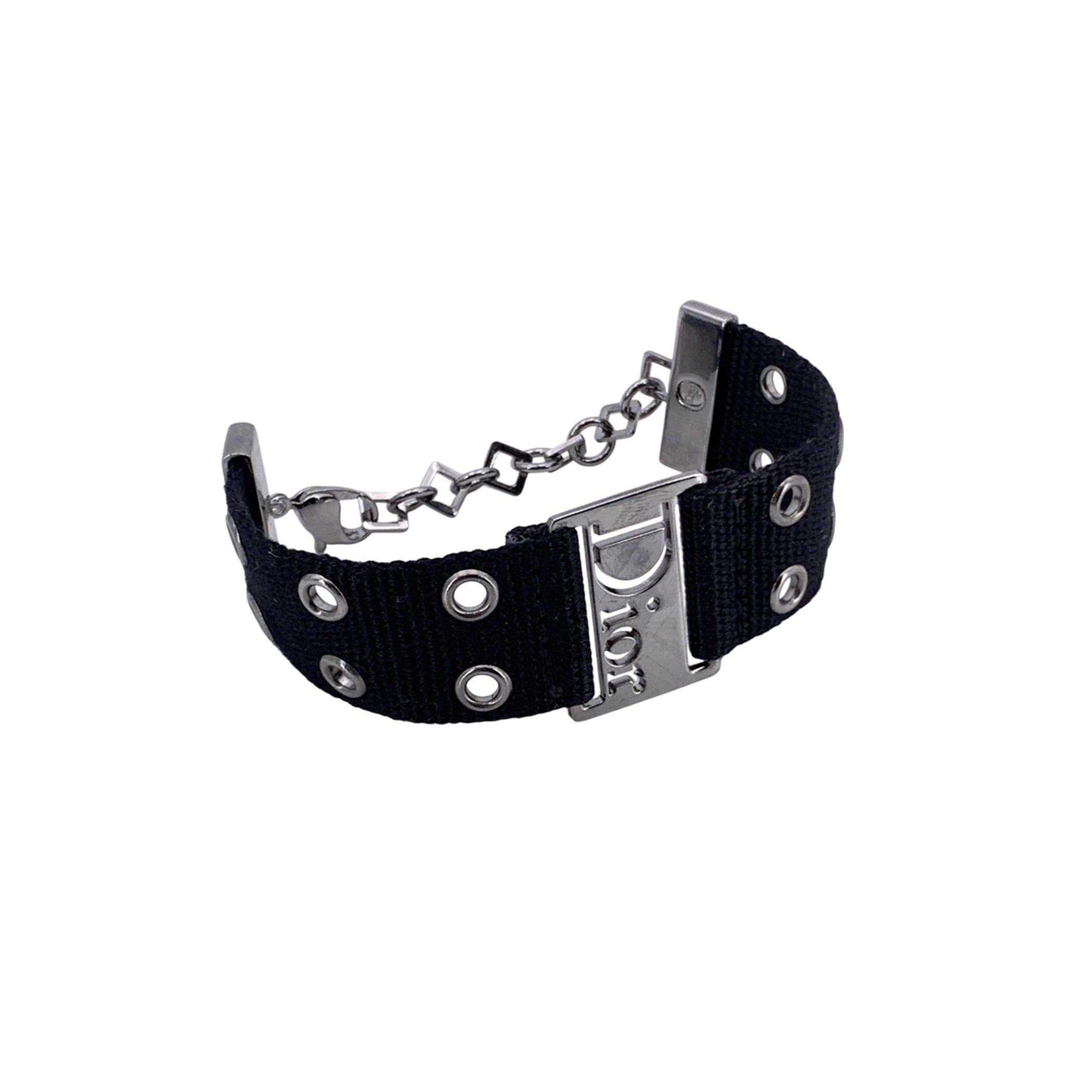Make an ultra-cool statement with this unforgettable Dior Logo Strap 'Street Chic' Bracelet, a bold relic from the daring Galliano era of the House. Crafted with a sleek black fabric strap and finished in high-quality silver-tone metal, this piece