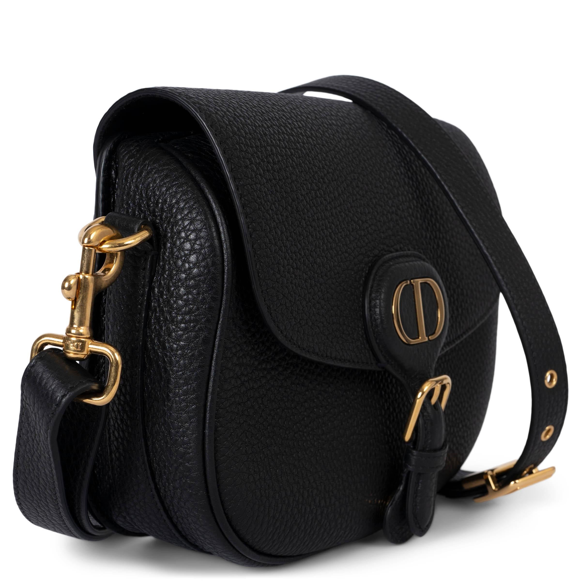This 100% authentic Dior Bobby Bag is crafted from supple black natural grained calfskin, showcasing elegant and refined craftsmanship. The bag features a spacious hobo silhouette with harmonious proportions, complemented by antique gold-finish