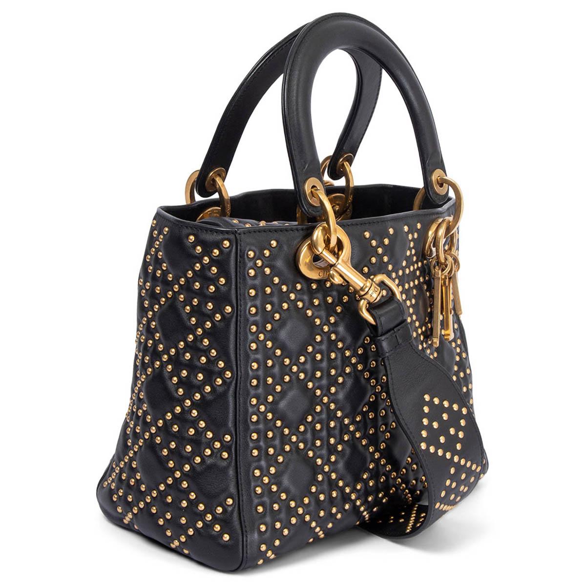 100% authentic Christian Dior Supple Lady Dior Medium bag in black studded Cannage mortif calfskin featuring aged gold-tone metal. Opens with a inner flap to a suede lined interior with one zipper pocket against the back and one open pocket against