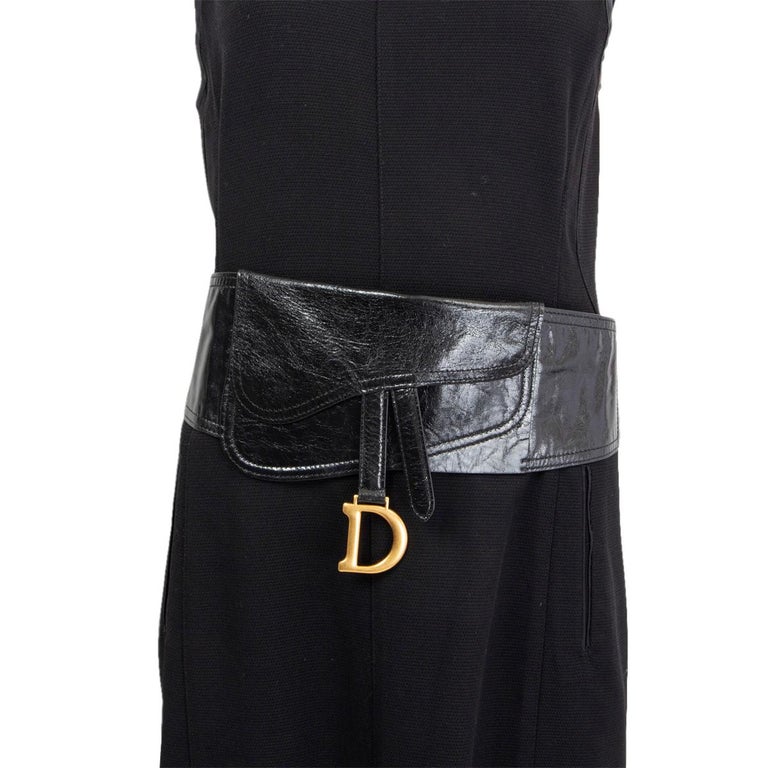 100% authentic Christian Dior Saddle waist belt in black crinkled lambskin embellished with a Saddle flap and shiny gold-finish metal 'D' stirrup charm. The design features two elastic bands for more extension. Has been worn and is in excellent