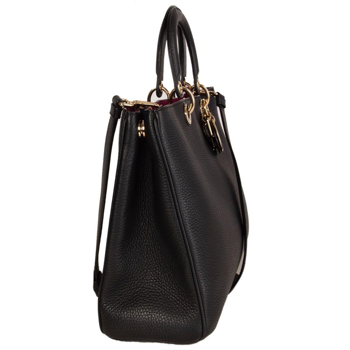 Christian Dior 'Diorissimo' tote shoulder bag in black grained calfskin featuring light gold-tone hardware. Opens with a magnetic button on top and is lined in fuchsia calfskin with two open pockets against the back with a detachable black grained