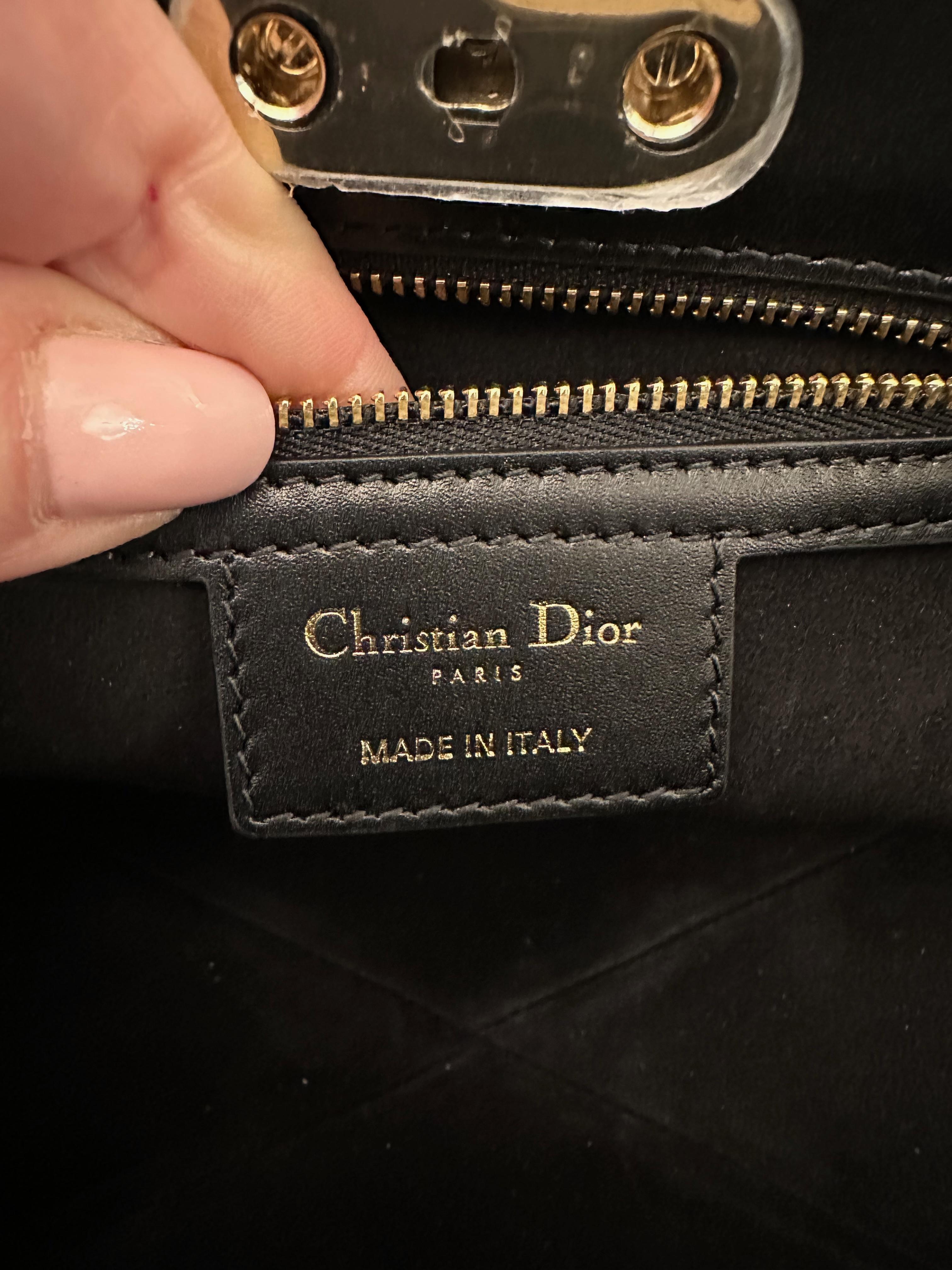 Inspired from the archives of the Christian Dior house, this Dior Key bag is crafted in a beautiful black box calfskin leather.
It feaures 2x handles allowing a hand or shoulder carry. The closure is to remind a key lock.
The inside is lined with a