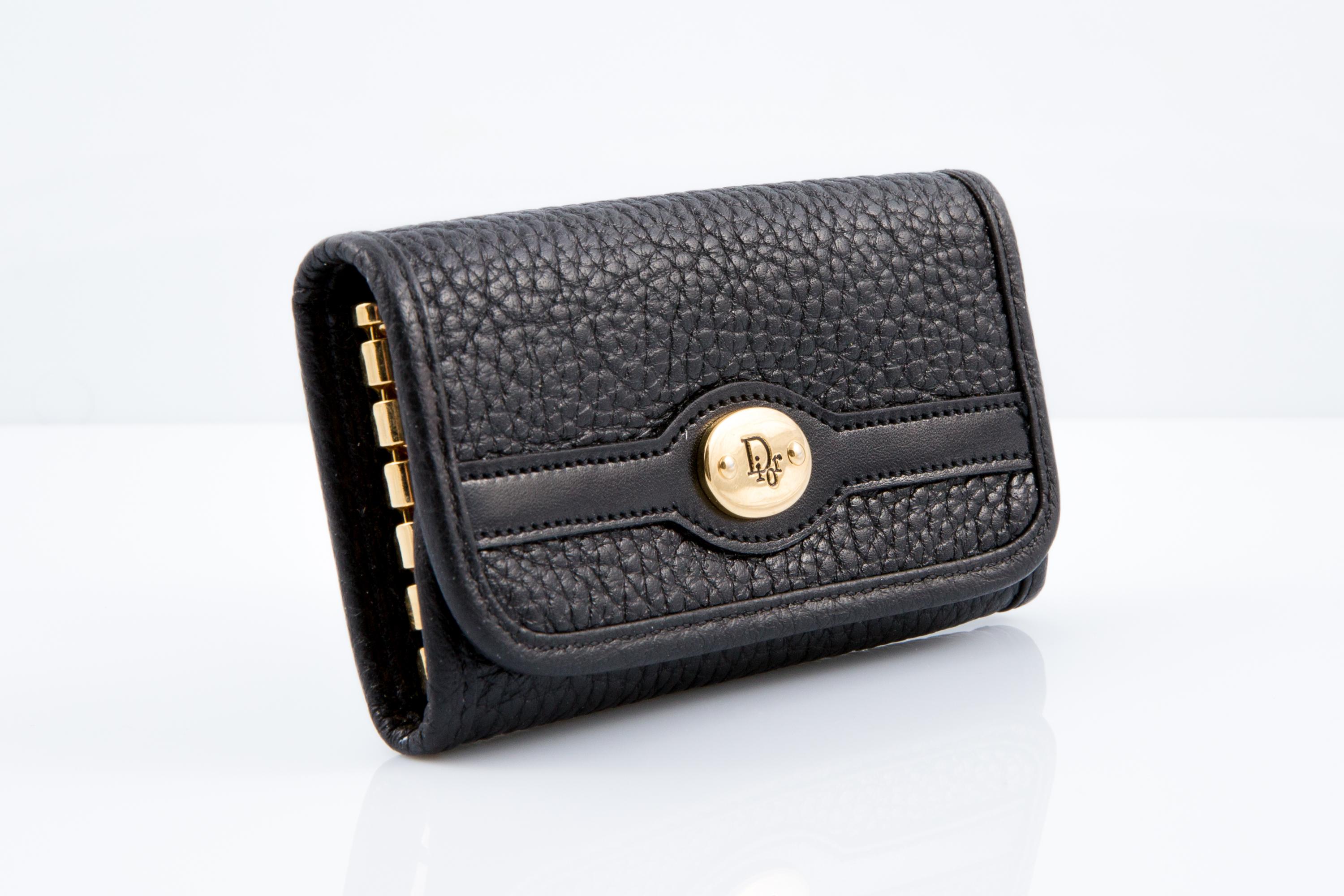Christian Dior Black leather six-hook key-case featuring a tri-fold design,a logo press-stud fastening, gold-tone hardware, internal key hooks, an internal logo stamp. 
100% leather. Circa 2000s 
Good vintage condition. Made in France
Length: 3.9in
