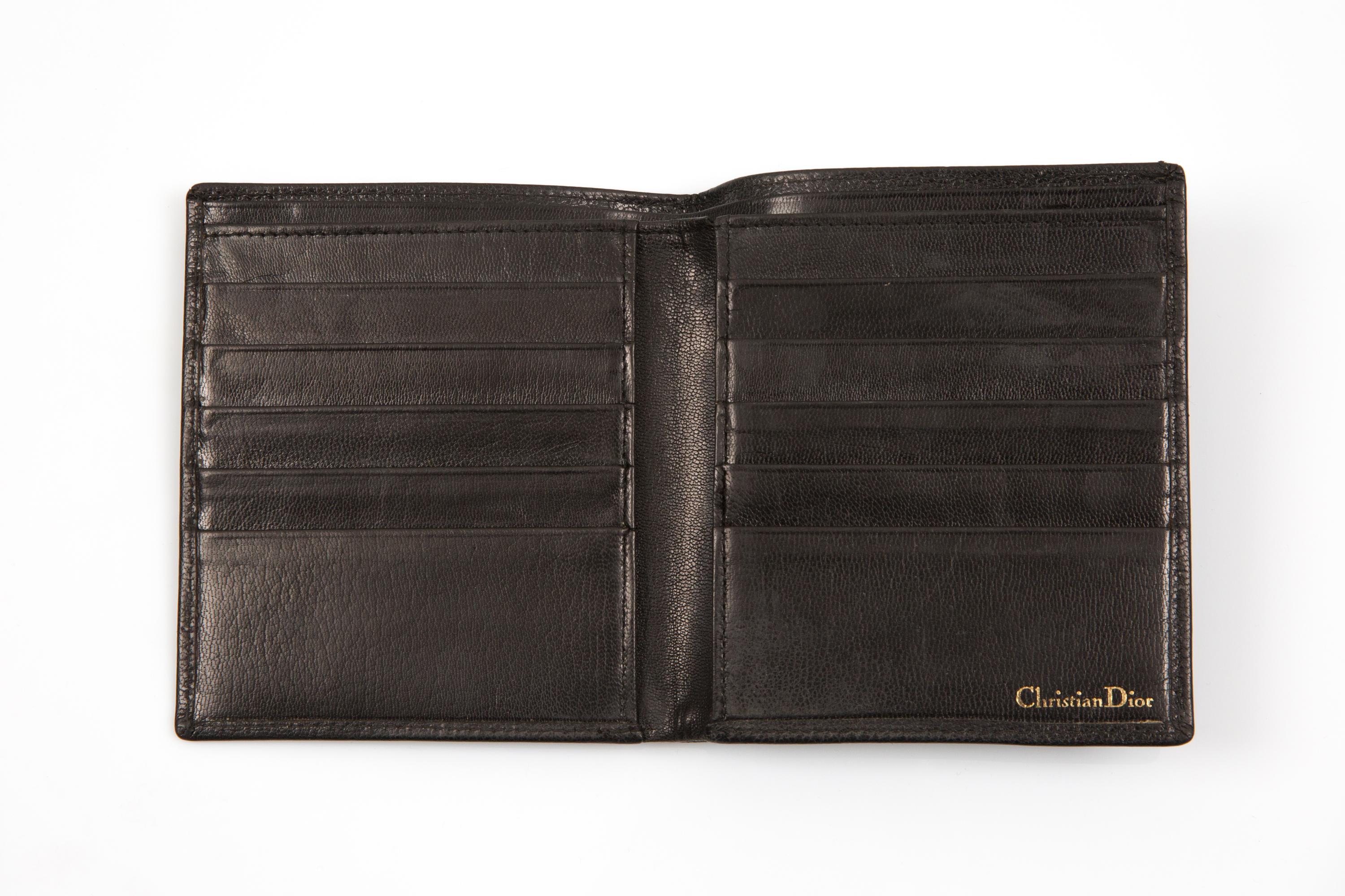Portefeuille Christian Dior en cuir noir avec un logo embossé sur le devant et un tampon à l'intérieur, 10 compartiments à cartes. 
Circa 1990  Fabriqué en France
Bon état vintage. 
Longueur : 11 cm
Hauteur : 11,5 cm (4,5 in)
Largeur : 0.39in