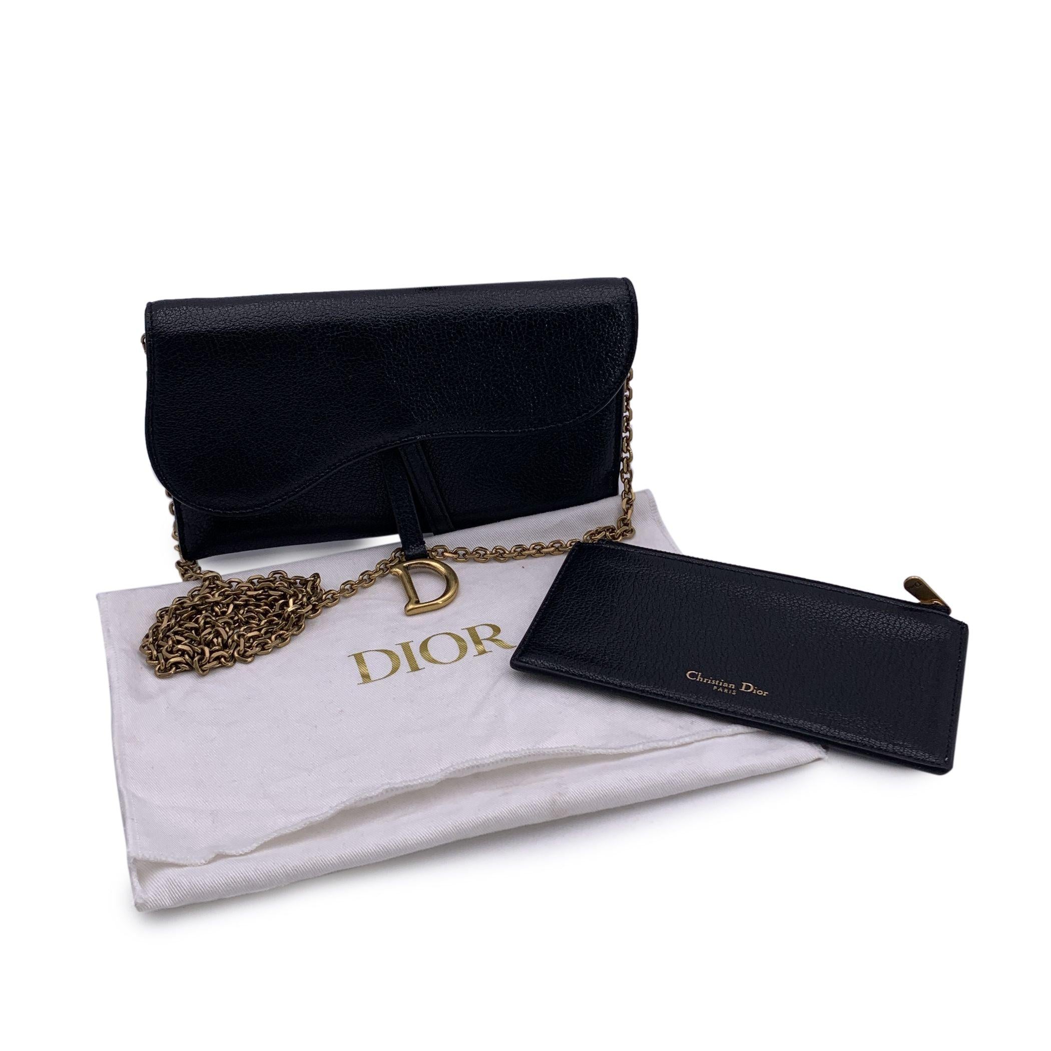 Gorgeous CHRISTIAN DIOR Saddle WOC Wallet on chain, made of Black shiny leather. Saddle flap is embellished with the classic D-shaped stirrup detail in gold metal. It wiil come with a removable chain shoulder strap. It can be carried by hand, over