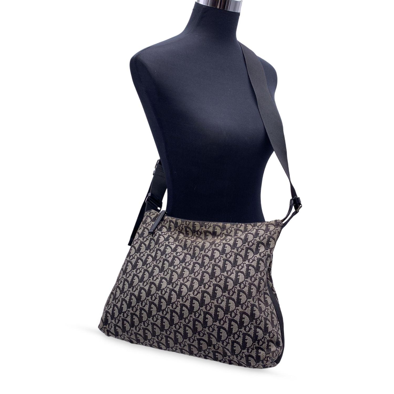 Christian Dior black Logogram Canvas shoulder bag. Canvas and Genuine Leather trim. Silver metal hardware. Upper zipper closure. Black canvas lining. 1 zip pocket inside. Adjustable shoulder strap. 'Christian Dior Paris' tag inside. Made in Italy.