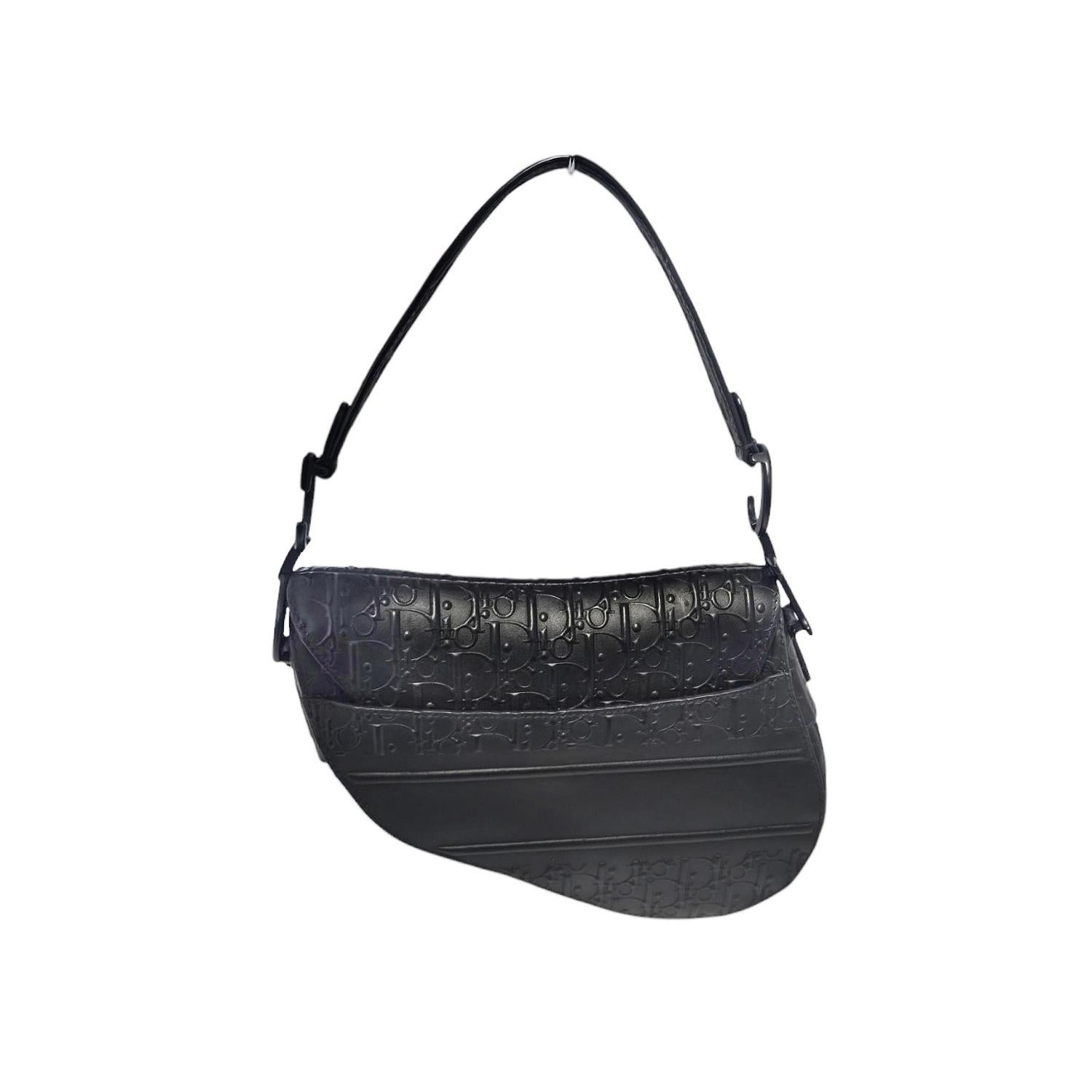 Ce sac Christian Dior en cuir de veau gaufré Oblique est réalisé en cuir gaufré Oblique classique de couleur noire. Il présente la forme de sacoche, une courte bandoulière en cuir avec une ancre 