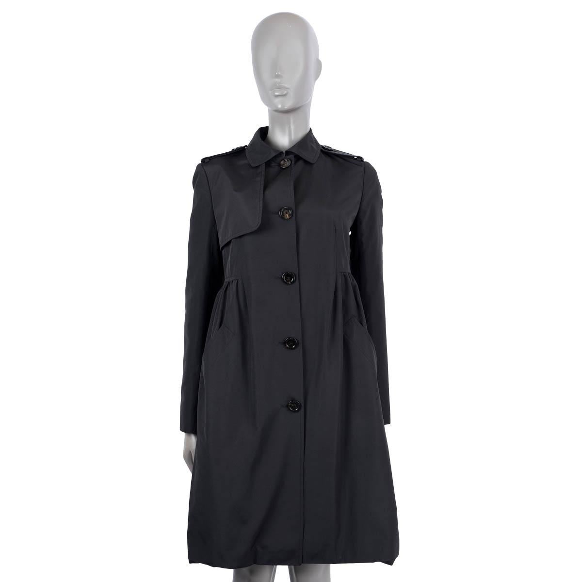 100% authentic Christian Dior buttoned trench coat in black silk (100%). The design features epaulettes on the shoulders, a gathered front, two side slit pockets and a round collar. Lined in black silk (100%). Has been worn and is in excellent