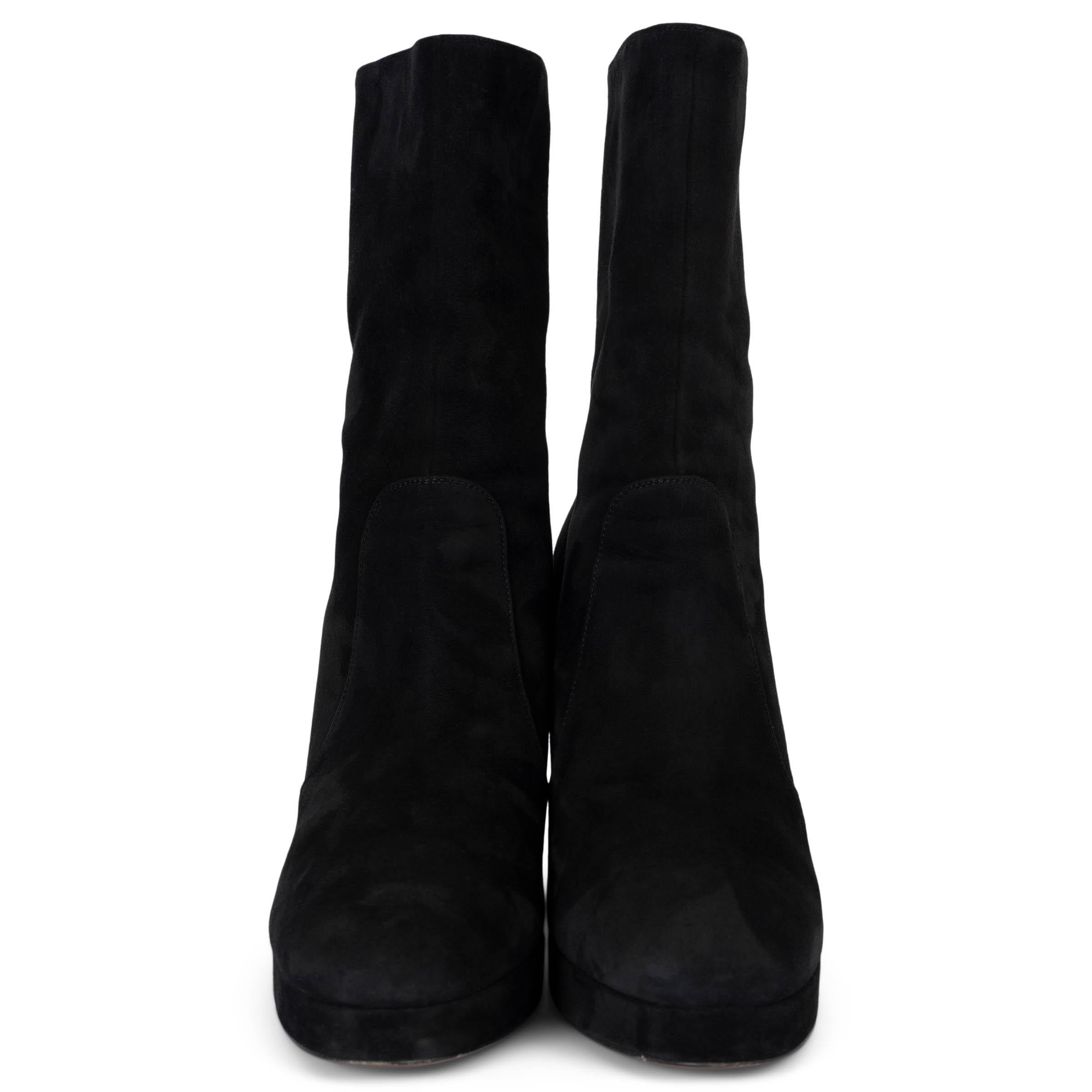 These 100% authentic Christian Dior D-Rise ankle boots in black suede offer a striking blend of elegance and edge. They feature a platform sole, almond toes, and a stacked leather block heel adorned with gold-tone 