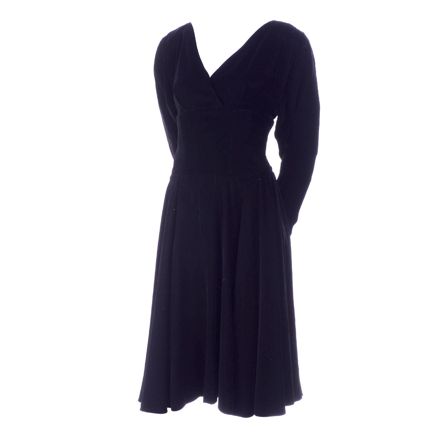 Voici une magnifique robe de soirée vintage en velours noir de Christian Dior avec une jupe ample.  La robe est munie de boutons et d'une fermeture à glissière qui commence à la taille dans le dos.  Le corsage croisé est au-dessus de la taille