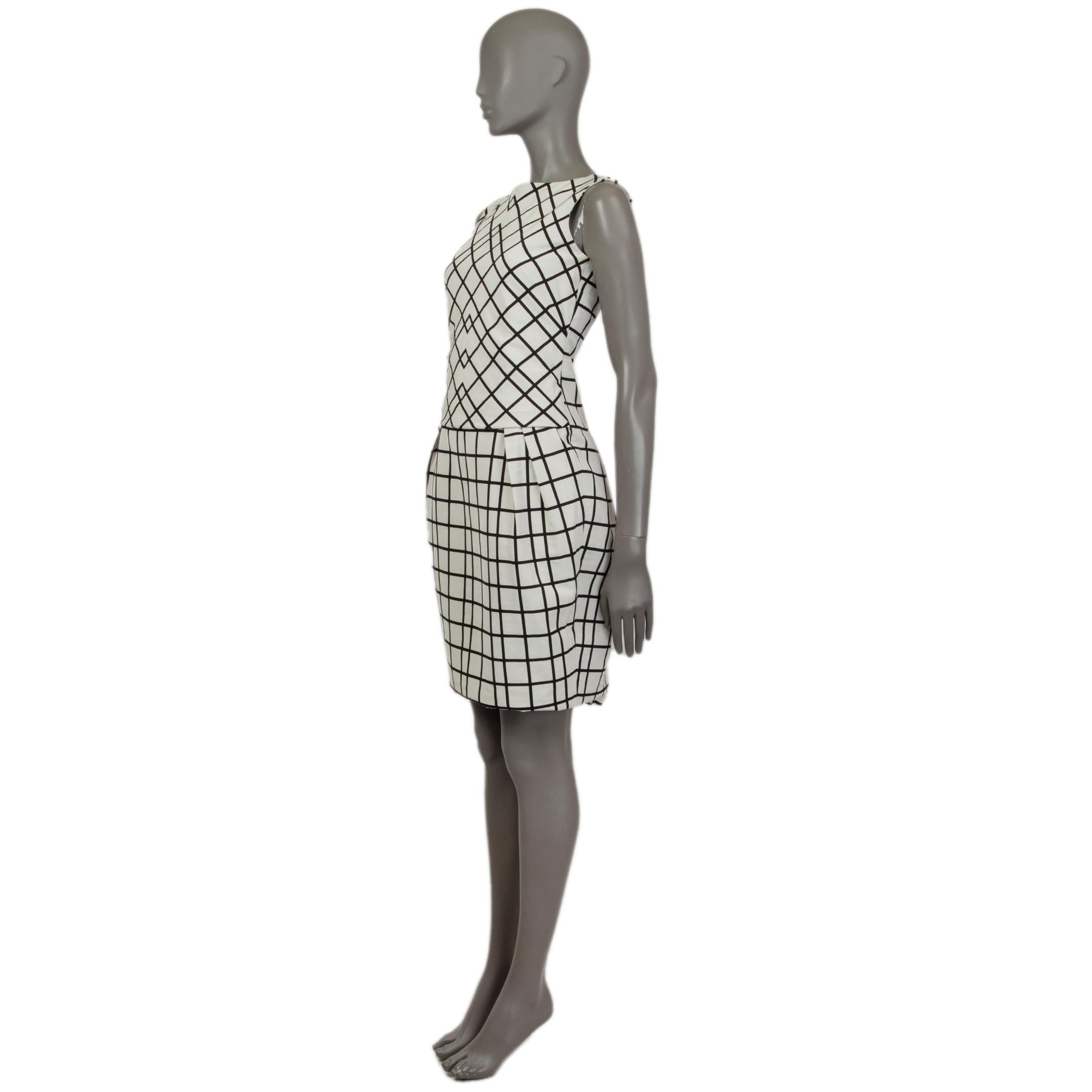 Christian Dior sleeveless plaid sheath dress in black and white cotton (69%) and polyester (31%). With round neck, pleated sides on front and back. Hooks from the top back, closes with invisable zipper in the back. Slit on the back bottom. Lined at