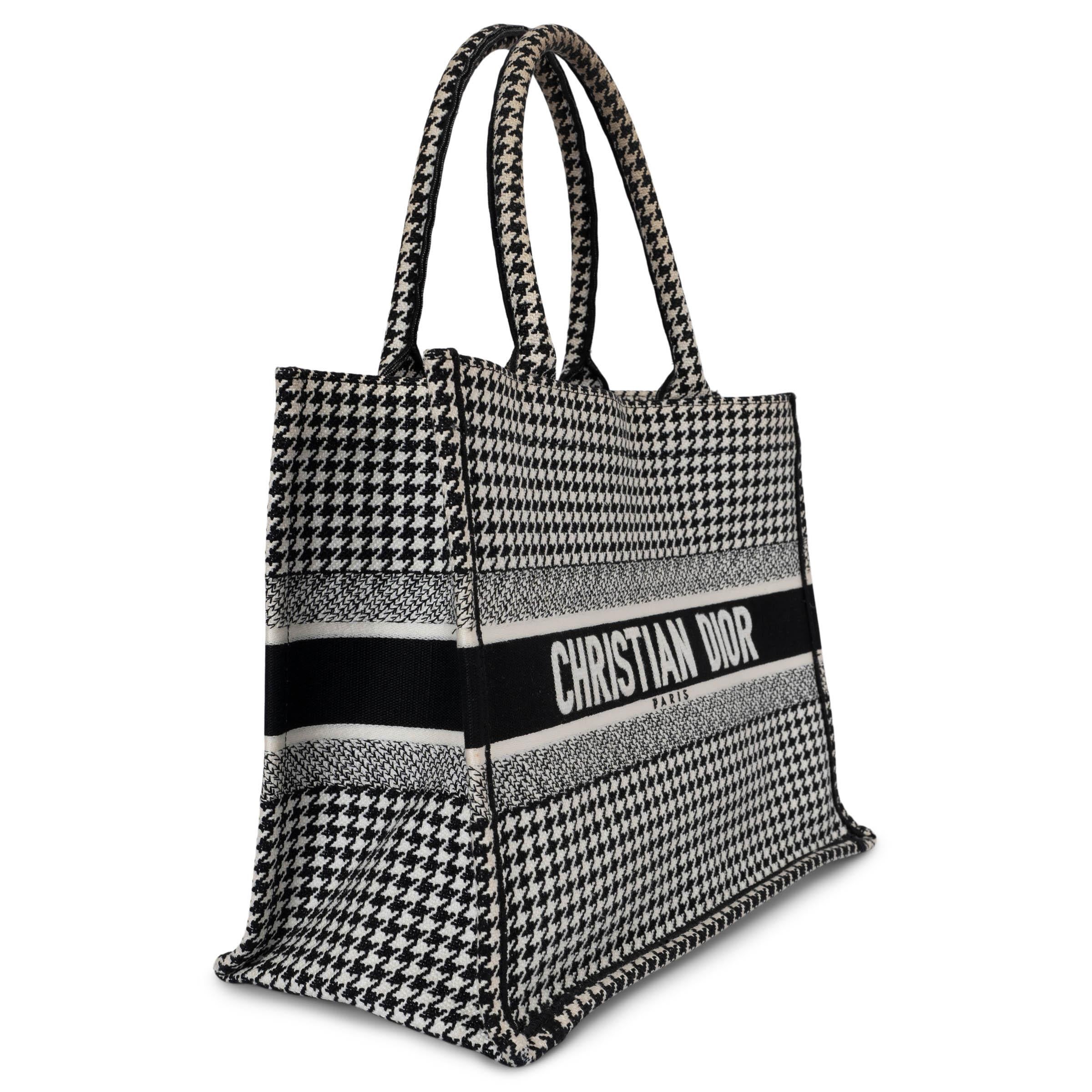 100% authentic Christian Dior Book Tote Medium in black and white houndstooth canvas. Has been carried and shows darkening to the handle and faint wear to the corners.  Overall in very good condition. 

Measurements
Height	27cm (10.5in)
Width	35cm