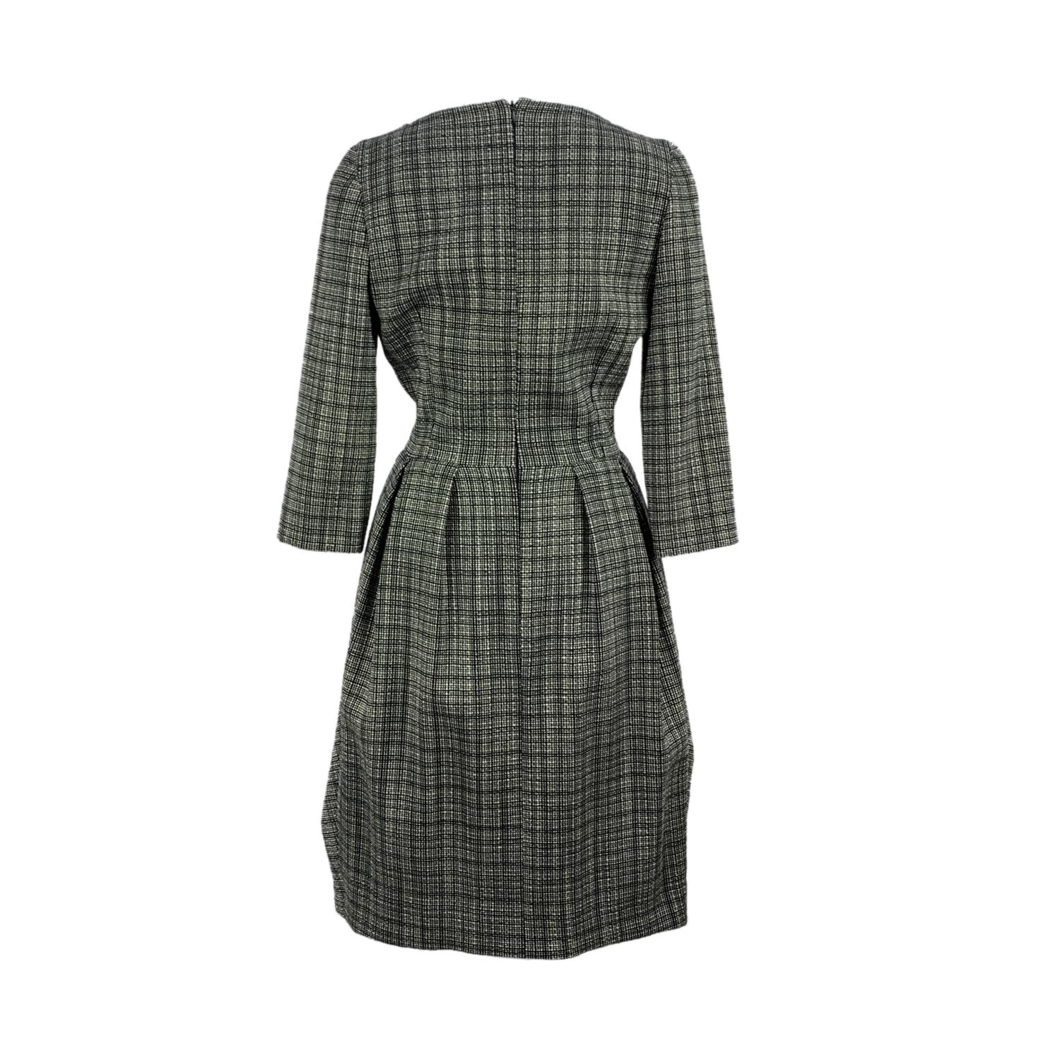 Christian Dior tweed wool dress in black and white colors hat make it look gray. Bow detailing on the front. Boat neckline and half-length sleeves. Knee length. Silk lining. Rear zip closure. Size: 40 FR, 12 GB, 44 IT, 38 D, 8 USA (it should