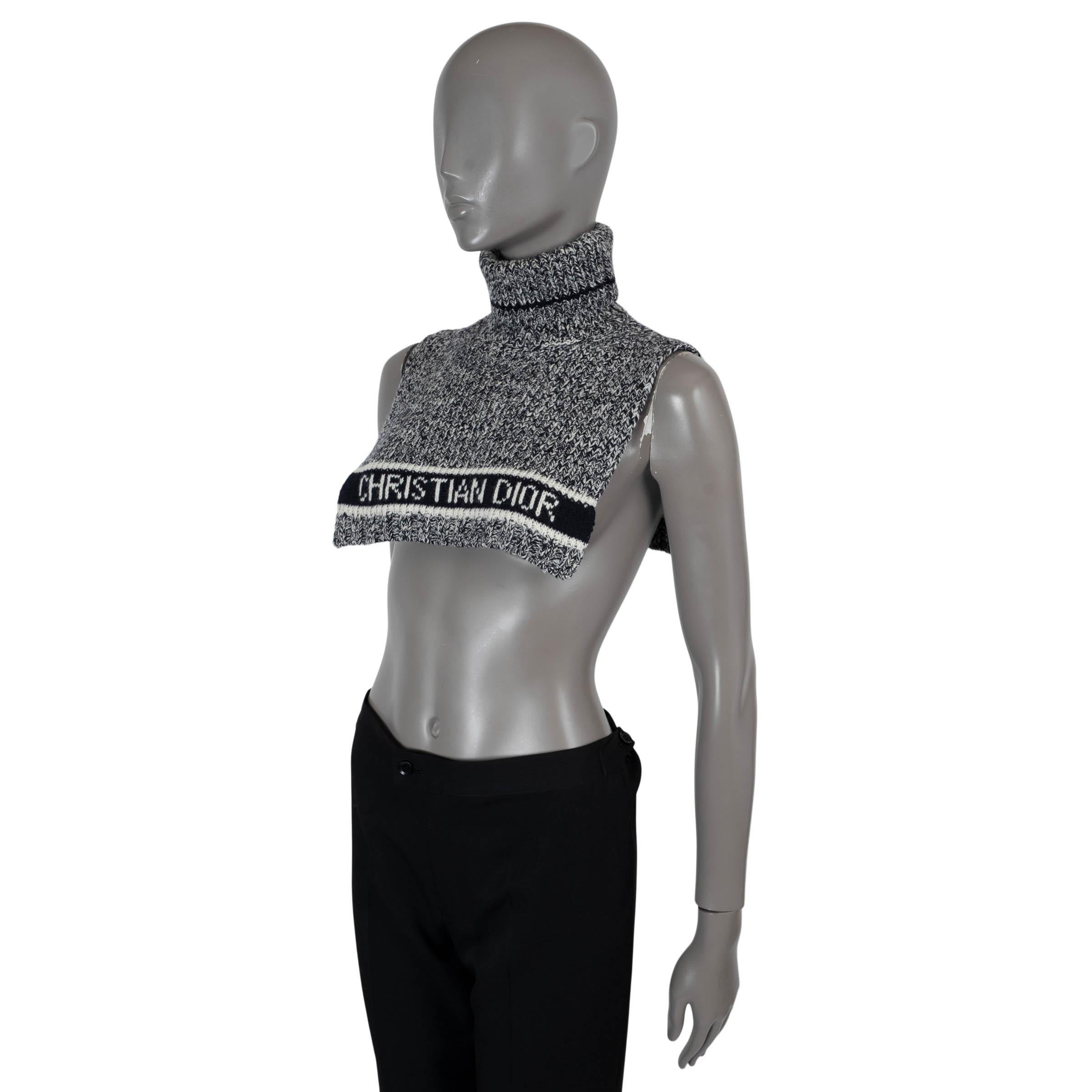 This 100% authentic Christian Dior turtleneck poncho is crafted from a luxurious black and white mélange blend of wool (70%) and cashmere (30%), offering both warmth and sophistication. It features a bold logo pattern on the frontand a sleek black