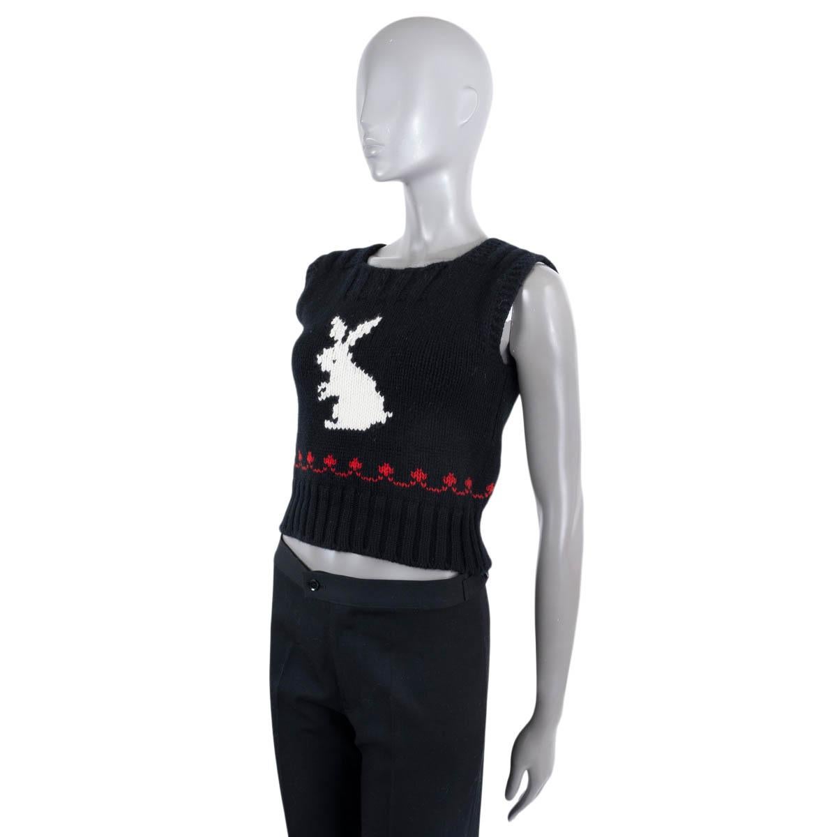 Gilet Christian Dior en laine noire (70%) et cachemire (30%). Whiting présente une silhouette courte, une maille épaisse avec un ourlet et un col en tricot côtelé, un lapin en intarsia en blanc et des détails en rouge. A été porté et est en