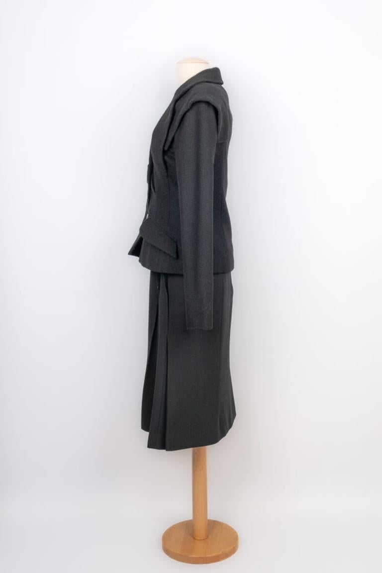 Dior - Ensemble en laine noire composé d'une jupe et d'une veste, doublé de soie. Aucune taille n'est indiquée, la veste convient à un 34FR/36FR et la jupe à un 38FR.

Informations complémentaires :
Condit : Très bon état.
Dimensions : Veste :