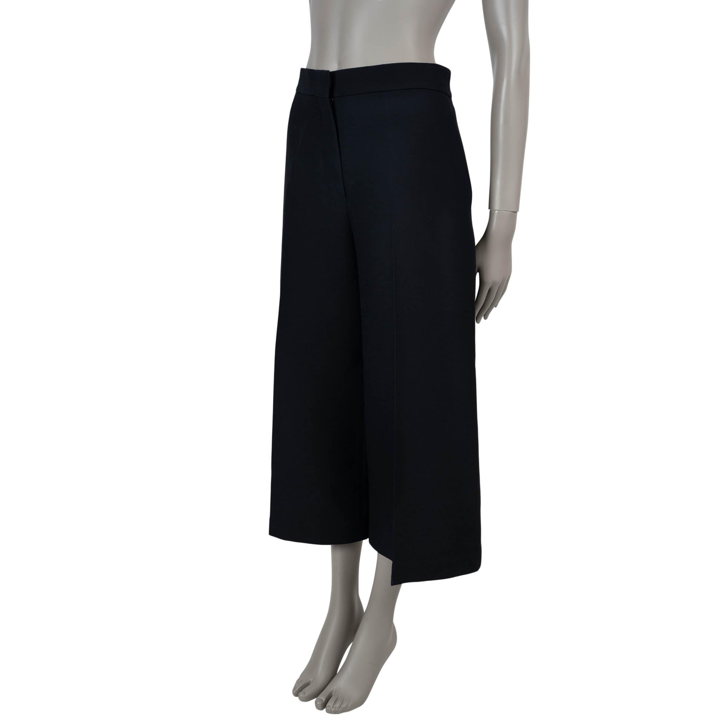 Ce pantalon court en laine et soie noire, 100% authentique Christian Dior, allie l'élégance sans effort à la précision du tailleur. Conçues avec une taille haute et de larges jambes mi-longues, elles offrent une silhouette à la fois raffinée et