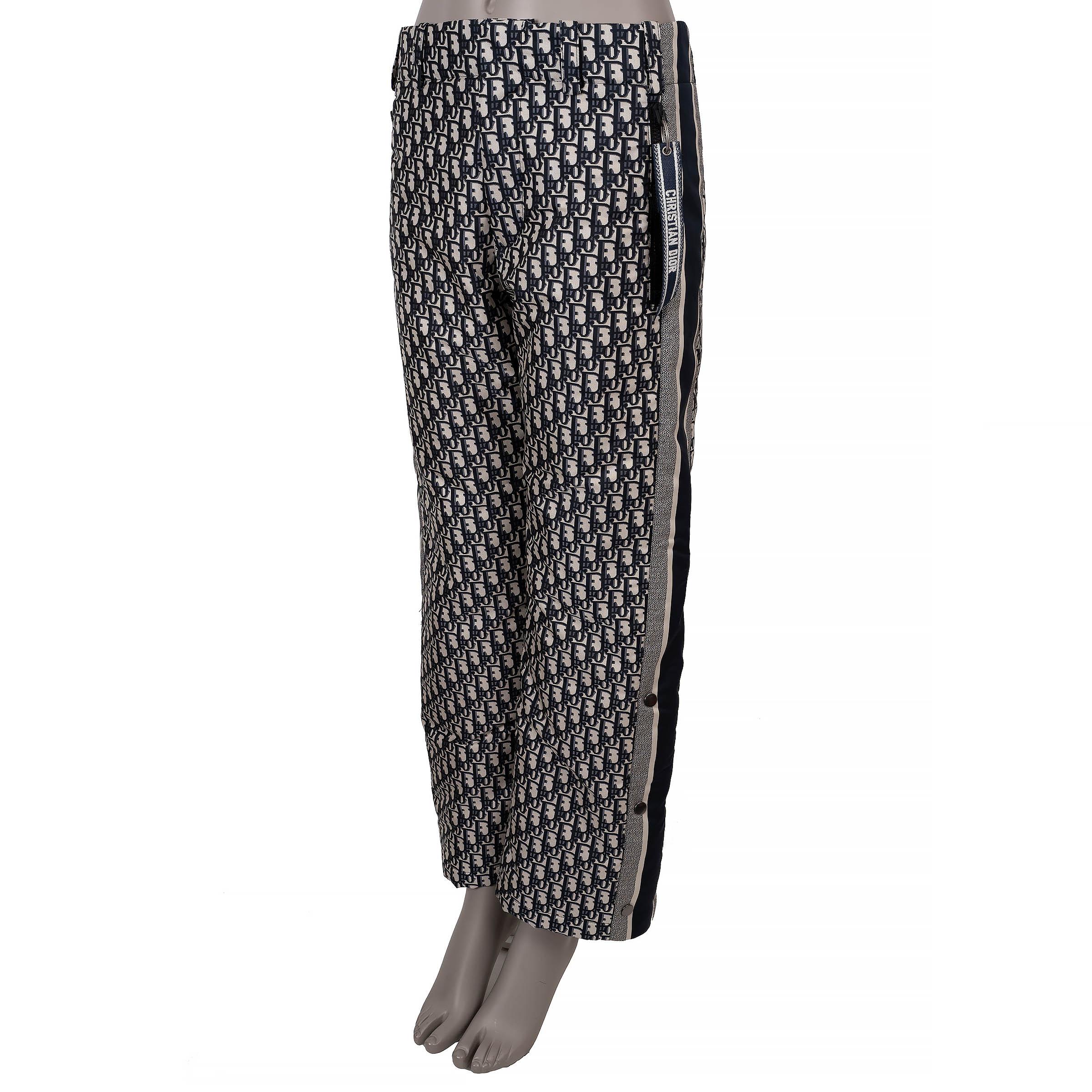Este pantalón 100% auténtico Christian Dior está confeccionado en poliéster tafetán técnico oblicuo azul y crema (100%). Presentan una elegante silueta de pierna recta con tiras laterales y puños abotonados a presión, diseñados para ofrecer