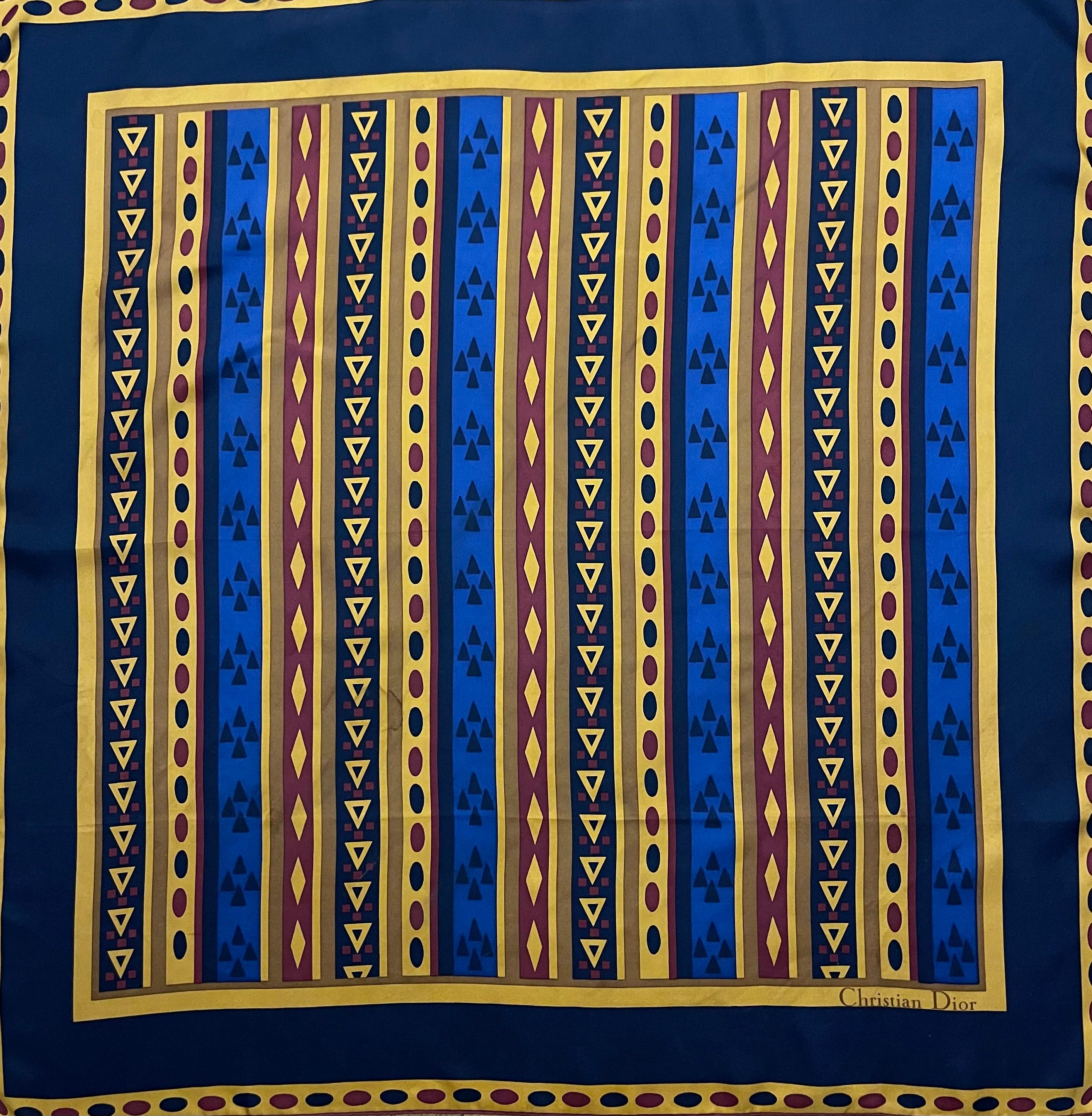 Foulard en soie bleu et jaune Christian Dior. Ce foulard Christian Dior se compose d'une base en soie encadrée d'une bordure marine profonde, ornée de motifs complexes d'inspiration baroque dans une disposition symétrique. Elegant et intemporel, il