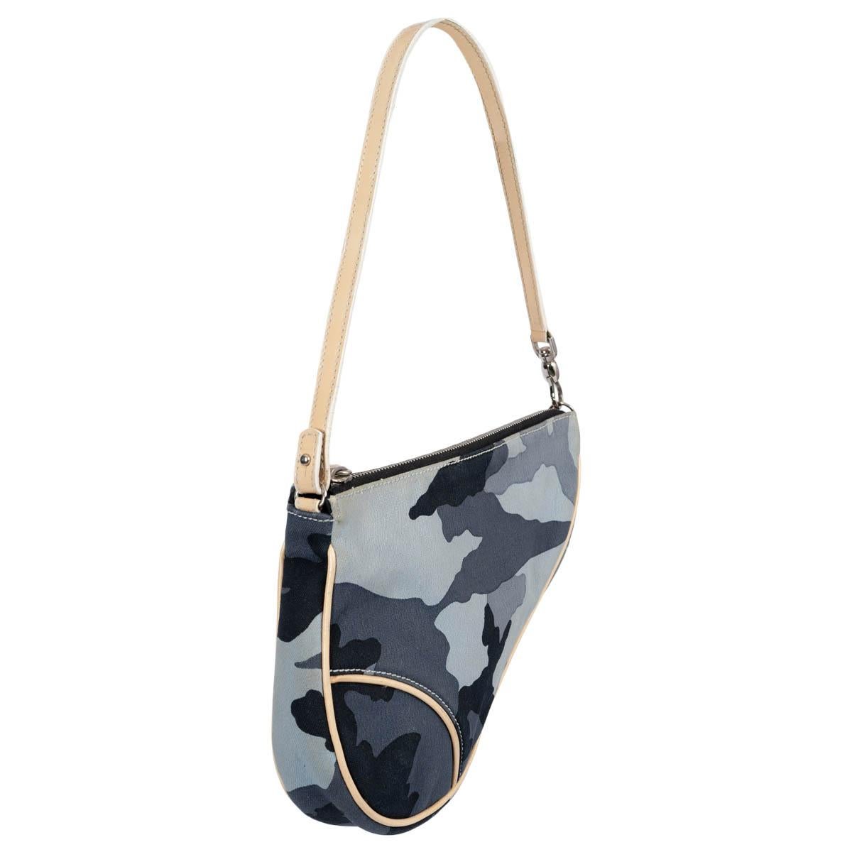 100% authentic Christian Dior by John Galliano Mini Saddle pochette bag in blue camouflage canvas with cream leather trims. Closes with zipper on top and is lined oblique monogram nylon. Has been carried and is in excellent condition. Comes with
