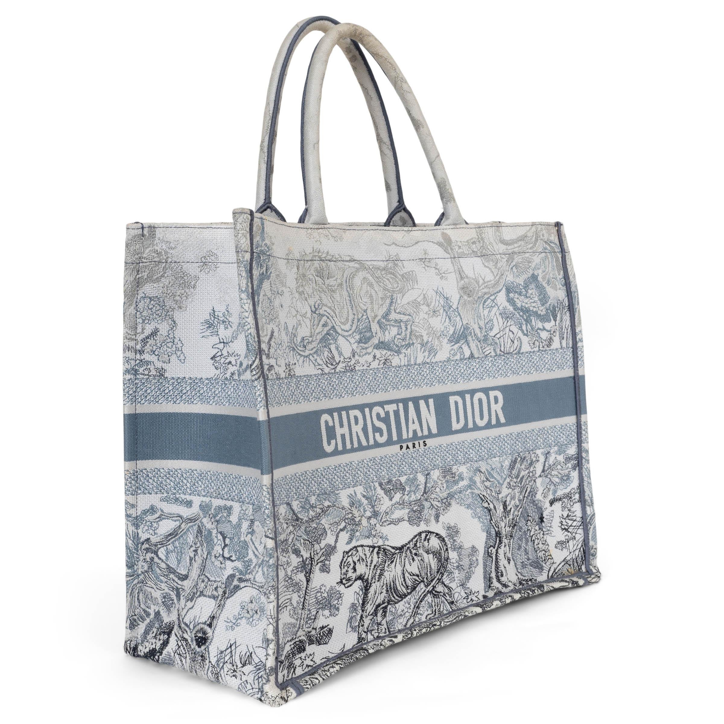 This 100% authentic Christian Dior Large Book Tote is finely crafted from embroidered canvas featuring a toile de Jouy pattern in gradient blue and grey. Designed for both elegance and practicality, it showcases matching multicolor canvas rolled