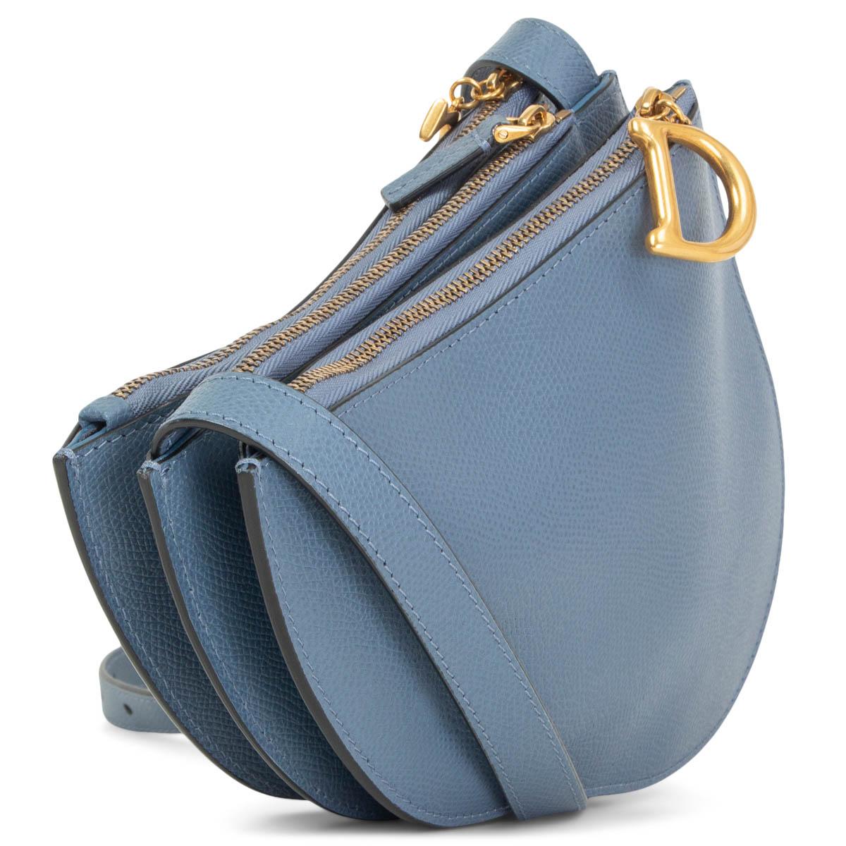 100% authentic Christian Dior Triple Zip Saddle crossbody bag in denim blue textured calfskin featuring a D&C charm on the outside zipper. Divided in three compartments and lined in denim blue suede. Comes with an adjustable shoulder strap. Has been