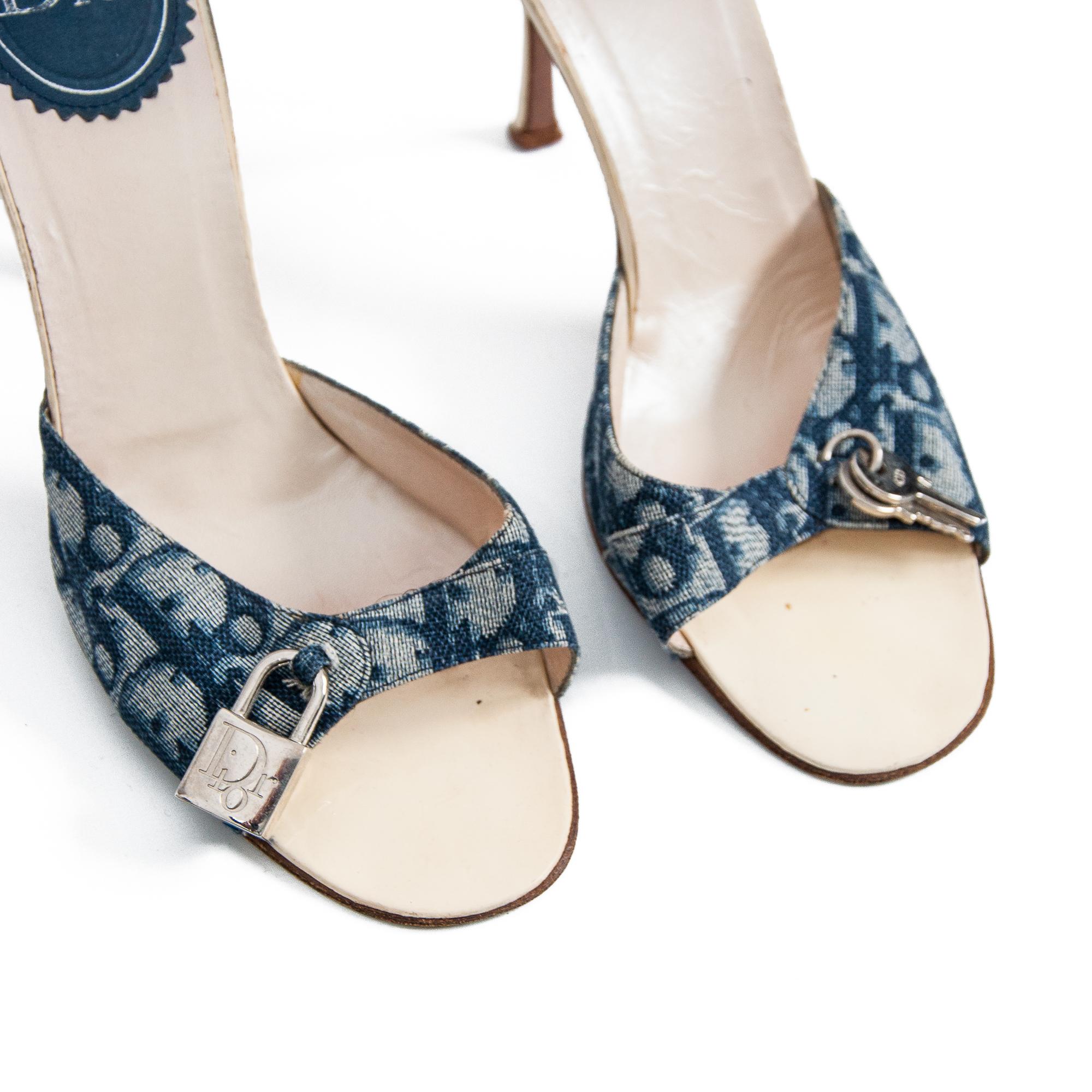 Vintage Christian Dior blue monogram high heels designed by John Galliano. An excellent presentation of 2000s era designer fashion. 

Padlock and key detail.

Blue Diorissimo monogram.
 
Leather soles.

Stilleto heel.

Vintage, circa 2000s.

Made in