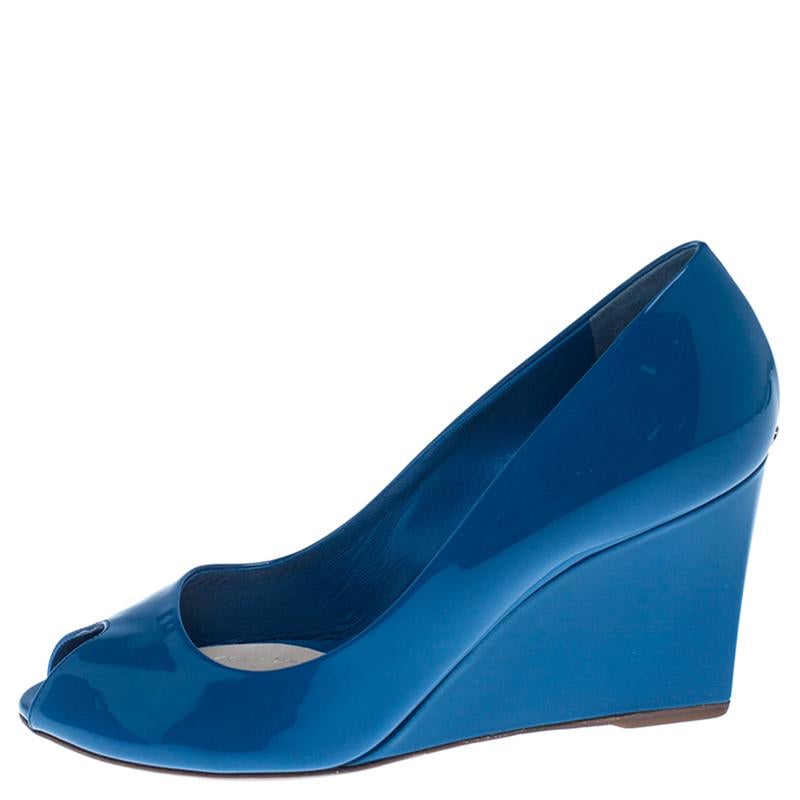 Timeless and comfortable, these pumps by Christian Dior will perfectly complement your work attire. They are made from blue patent leather with peep-toes. They feature 8.5cm wedge heels and leather-lined insoles.

Includes: Original Dustbag

