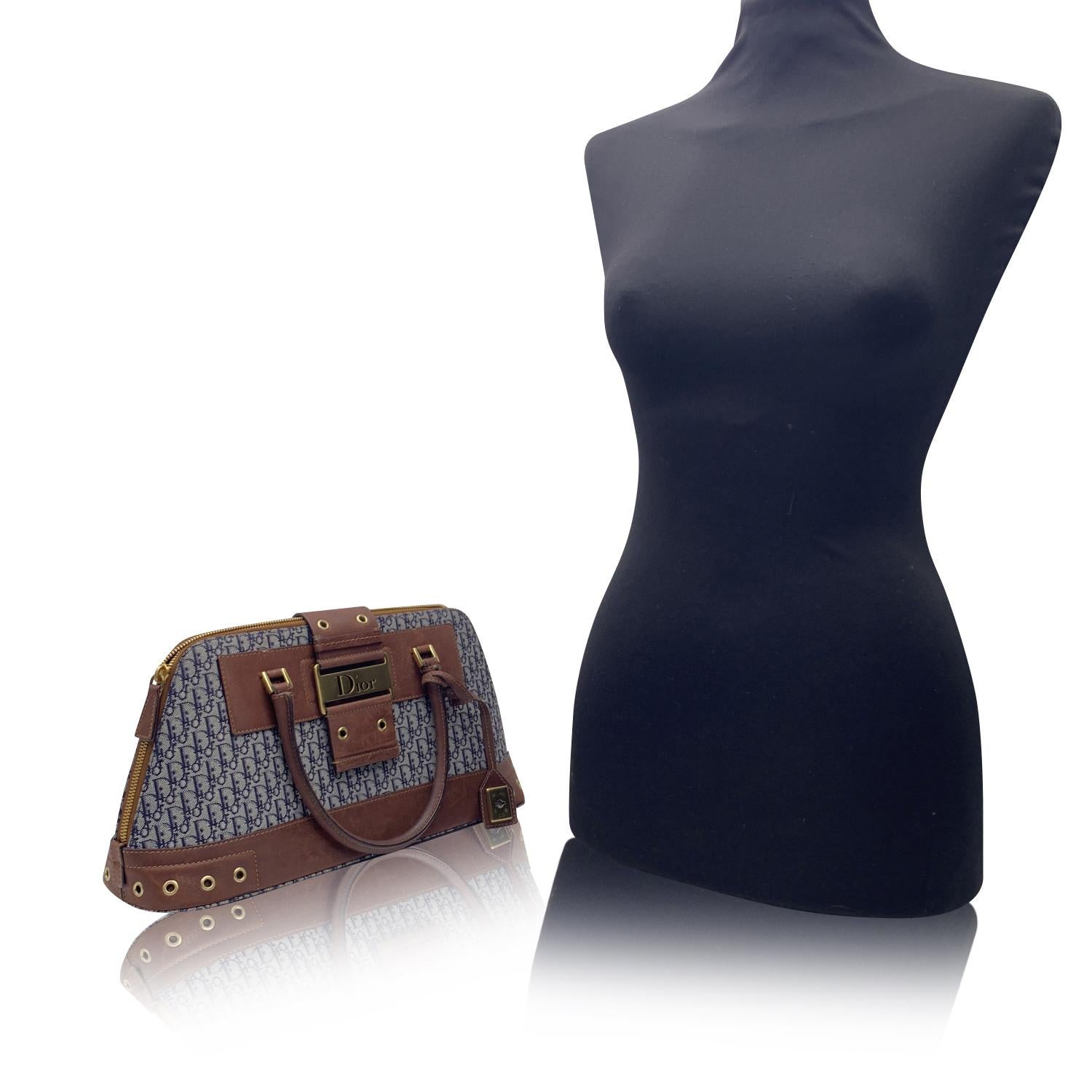 CHRISTIAN DIOR Trotter Street Chic Handtasche aus blauem Dior-Monogramm mit braunem Echtlederbesatz und Griffen. Goldfarbene Metallbeschläge. Die Tasche hat doppelte Henkel, ein ausgeschnittenes Dior-Logo auf der Vorderseite und einen oberen