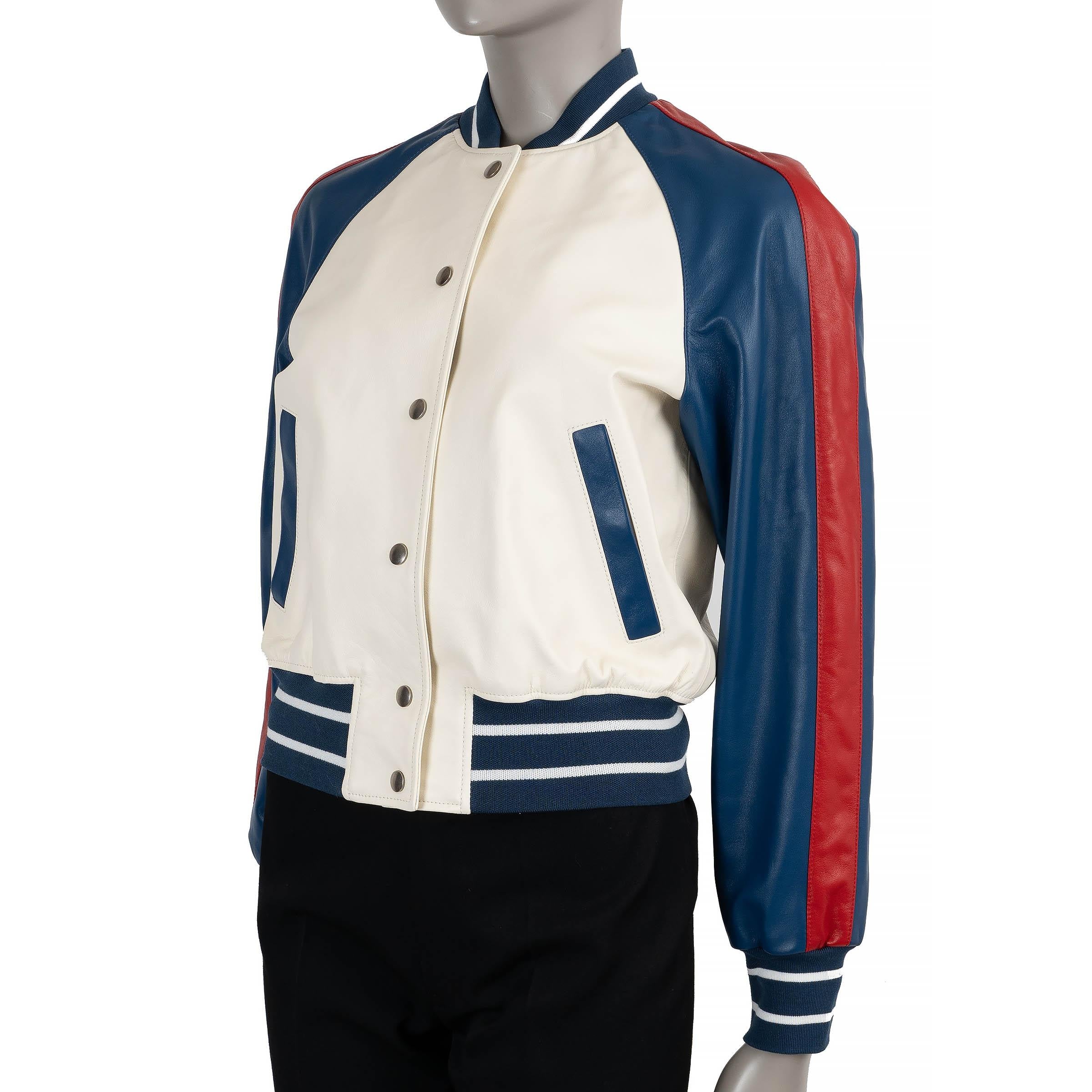 This 100% authentic Christian Dior bomber jacket is crafted in cream lambskin leather with contrasting navy blue sleeves accented by a red side stripe. The back features a bold 