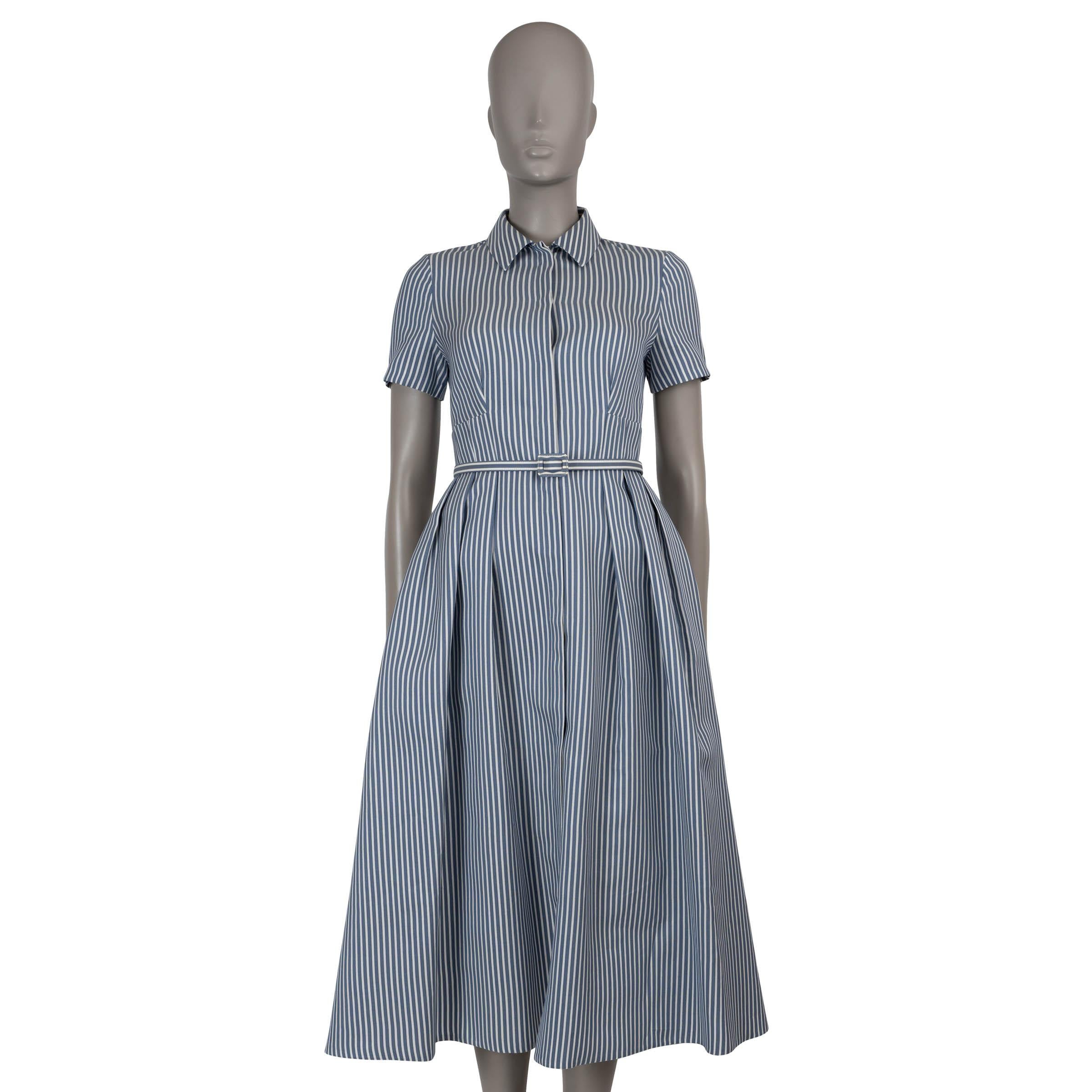 This 100% authentic Christian Dior shirt dress in blue and white striped silk (52%) and cotton (45%) blends effortless elegance with timeless tailoring. Designed with a fit and flare silhouette, it cinches at the waist with a matching buckled belt