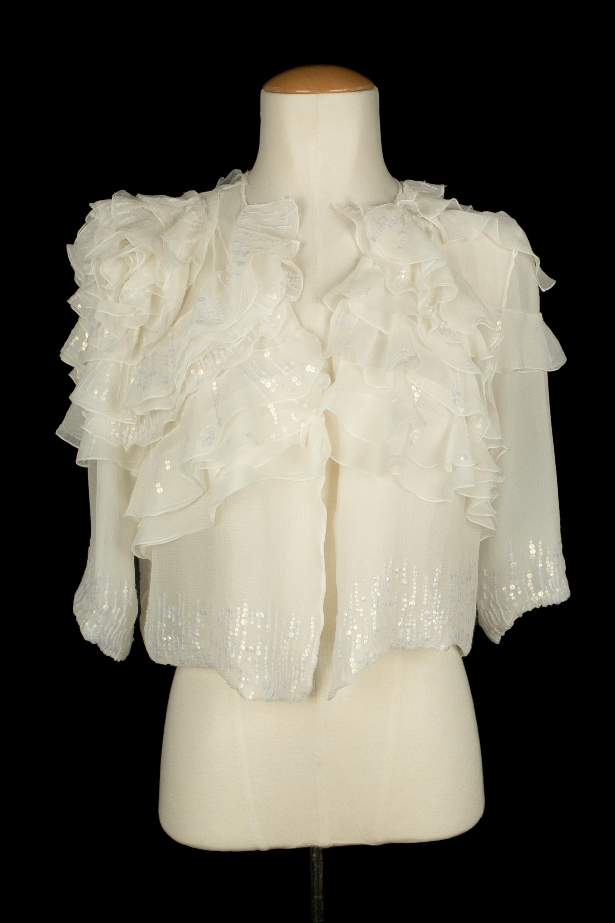 DIOR - Giacca bolero in mussola bianca ricamata con paillettes. Non è indicata la taglia, ma si adatta a una 36FR.

Condizioni:
Ottime condizioni

Dimensioni:
Lunghezza: 48 cm - Lunghezza maniche: 38 cm

SKU:FV69