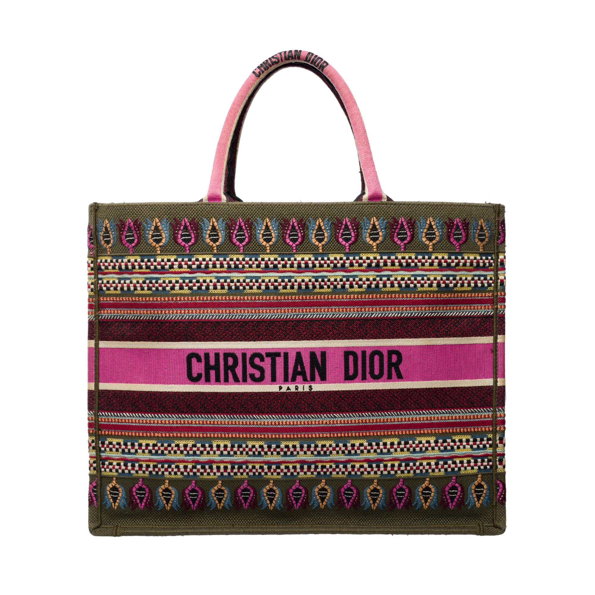 Essential​ ​Dior​ ​Book​ ​Tote​ ​bag​ ​in​ ​multicolor​ ​canvas,​ ​with​ ​double​ ​pink​ ​canvas​ ​handles​ ​for​ ​hand​ ​carry.

Multicolor​ ​canvas​ ​lining​ ​interior
Signature:​ ​