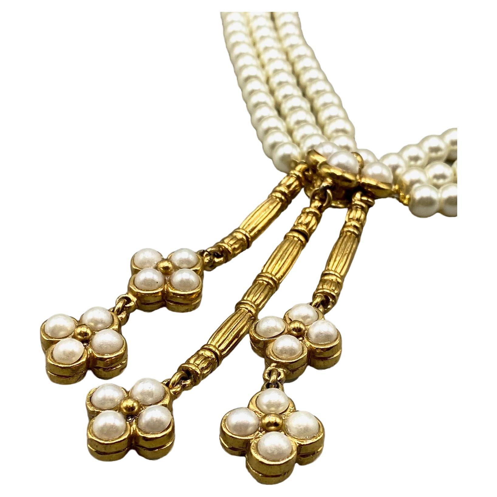 Presented is a 1980s three strand faux pearl necklace with gold tone and pearl pendants from the Christian Dior Boutique. The three strands are comprised of 8mm size glass interior faux pearls measure 1 inch wide lying flat. The stands meet in the