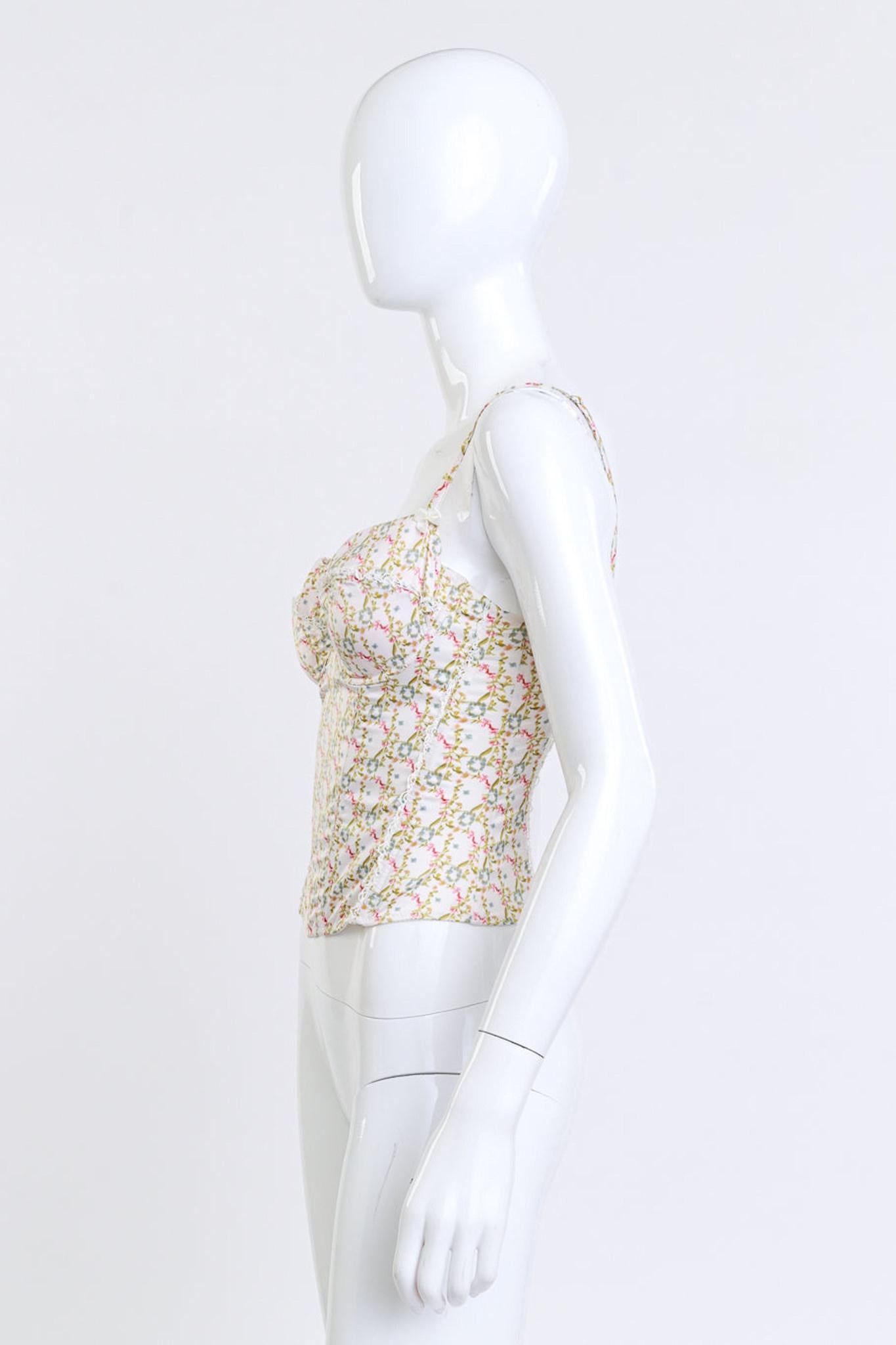 CHRISTIAN DIOR BOUTIQUE FLORAL PRINT BUSTIER (S/M)

This Christian Dior Boutique bustier from the Spring/Summer 2005 collection features a floral vine print on an eggshell base with blue, green, and red accents. It has inner underwire cups with lace