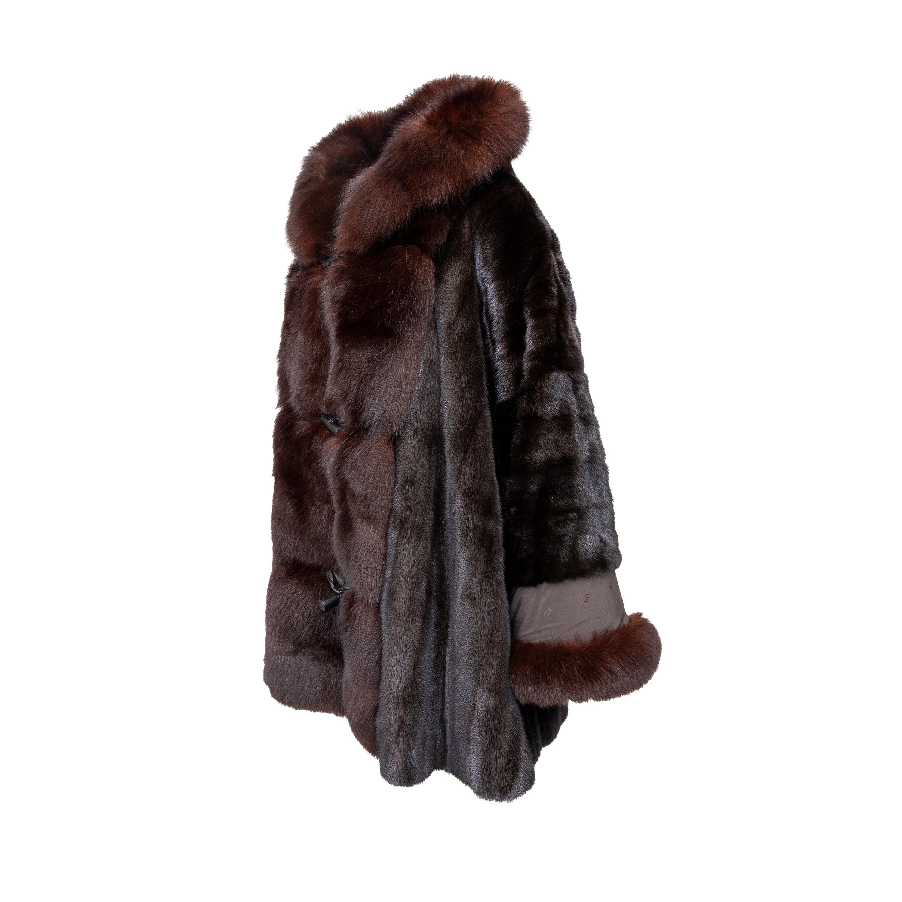In a rich dark mahogony color, made of mink fur. CD logo printed fabric as the lining and as a panel on the sleeve. The sleeve hem is made of fox fur, can be folded to style over the fabric panel. Leather covered toggle buttons on the front.