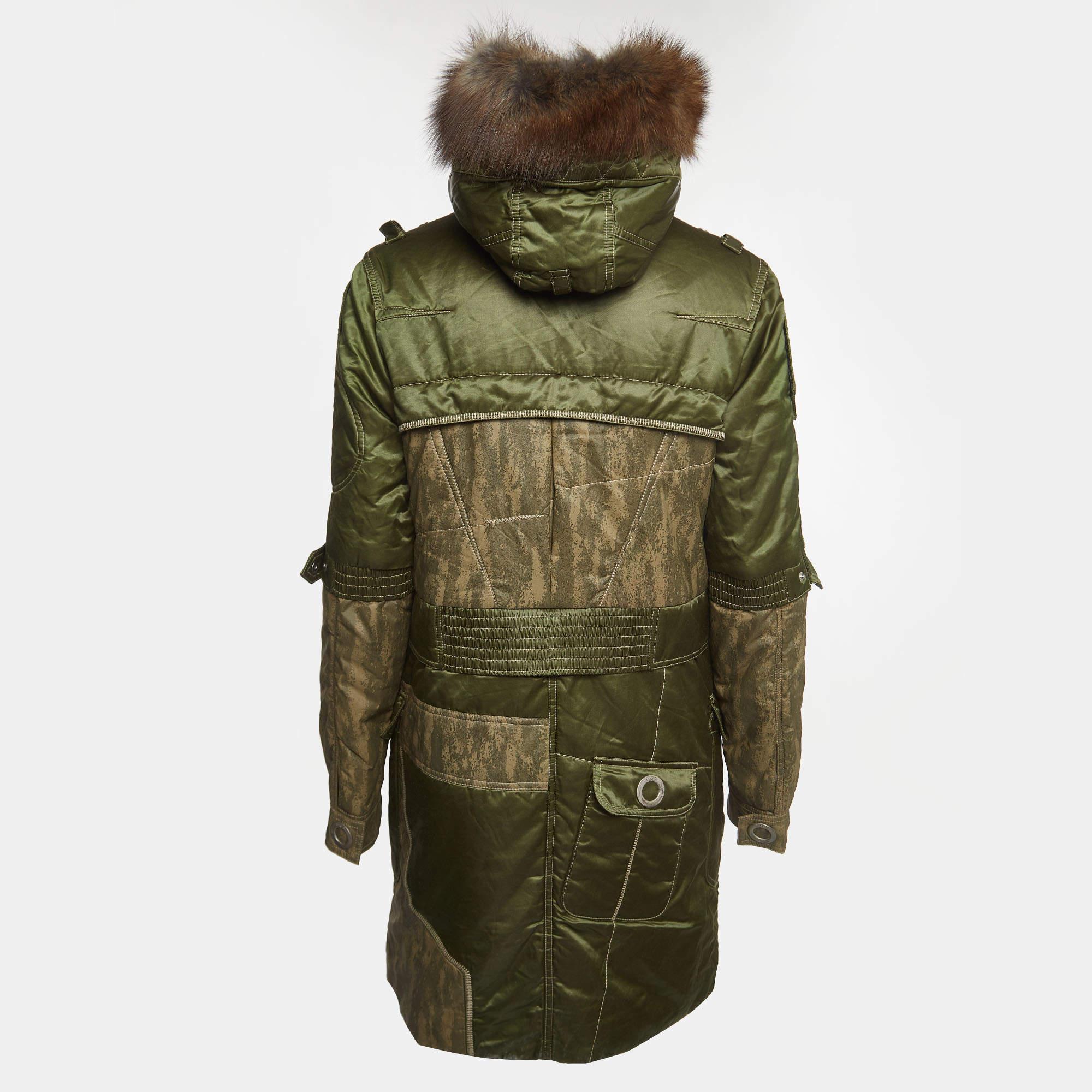 The Christian Dior Boutique parka jacket seamlessly blends luxury and functionality. Crafted with precision, this parka features a lush fur trim, elevating winter style. The rich green cotton blend exudes sophistication, making it a statement piece