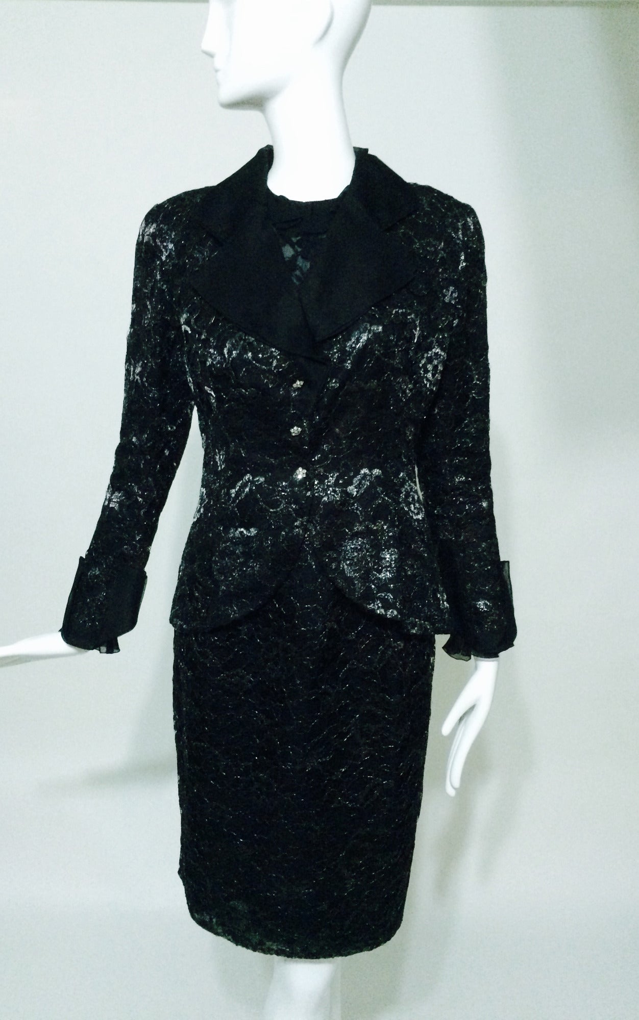 Christian Dior Boutique numbered black & silver lace skirt set with coordinating lace blouse.
The fitted lace jacket has a nipped waist with wide lapels and deep turn back cuffs of black silk organza, it closes at the front with decorative