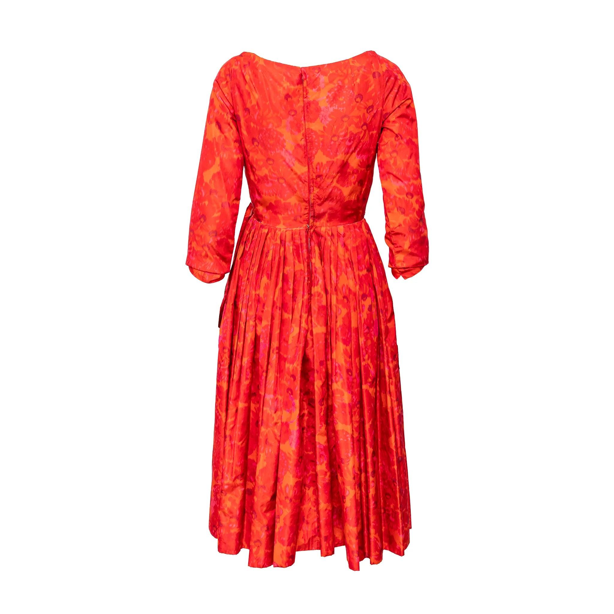 Exquisitamente diseñado por Monsieur Dior, este vestido de seda de la Boutique Christian Dior presenta un llamativo estampado floral de acuarela en un rojo vibrante. El favorecedor diseño envolvente con escote en V y el corsé de varillas incorporado