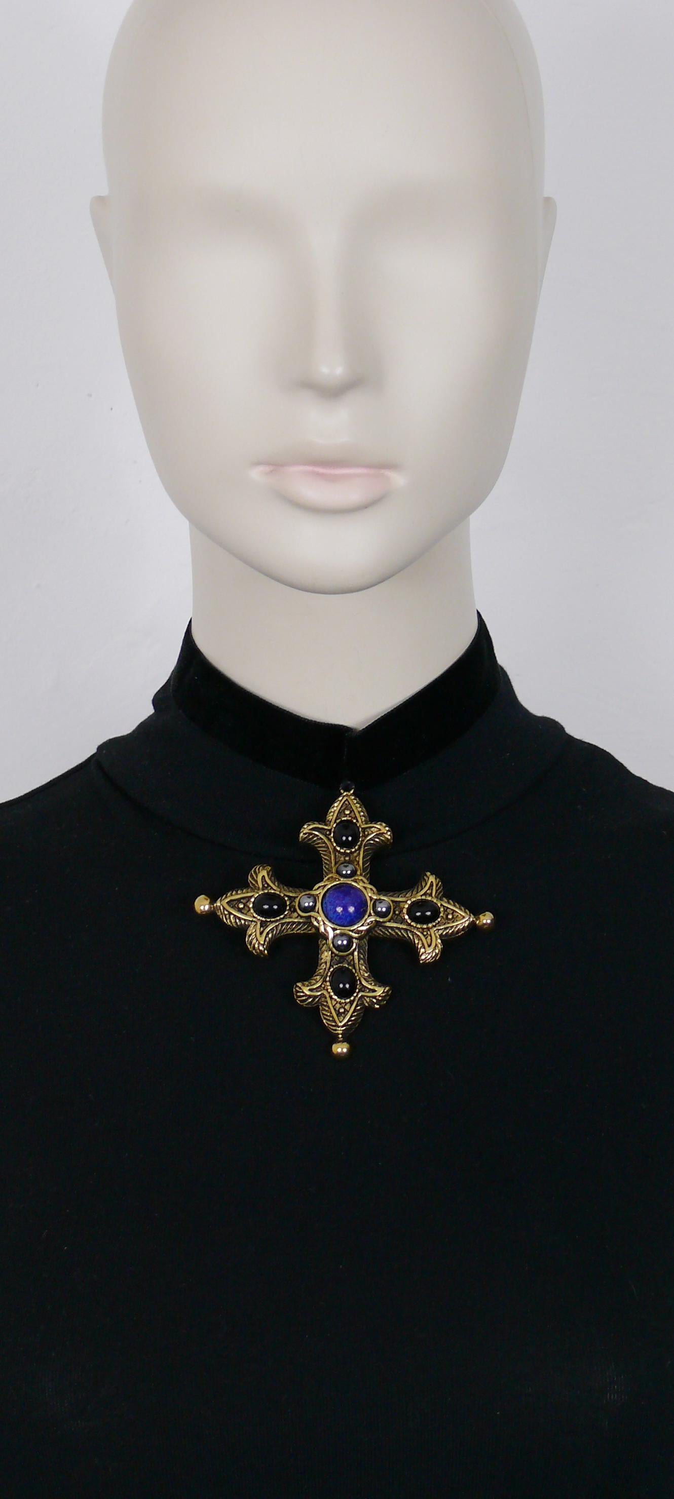 CHRISTIAN DIOR Boutique vintage antiqued gold toned cross pendant embellished with faux stones and black glass cabochons.

This cross pendant was recently sewn on a black velvet ribbon (see pictures 11 and 12).

Marked CHRISTIAN DIOR
