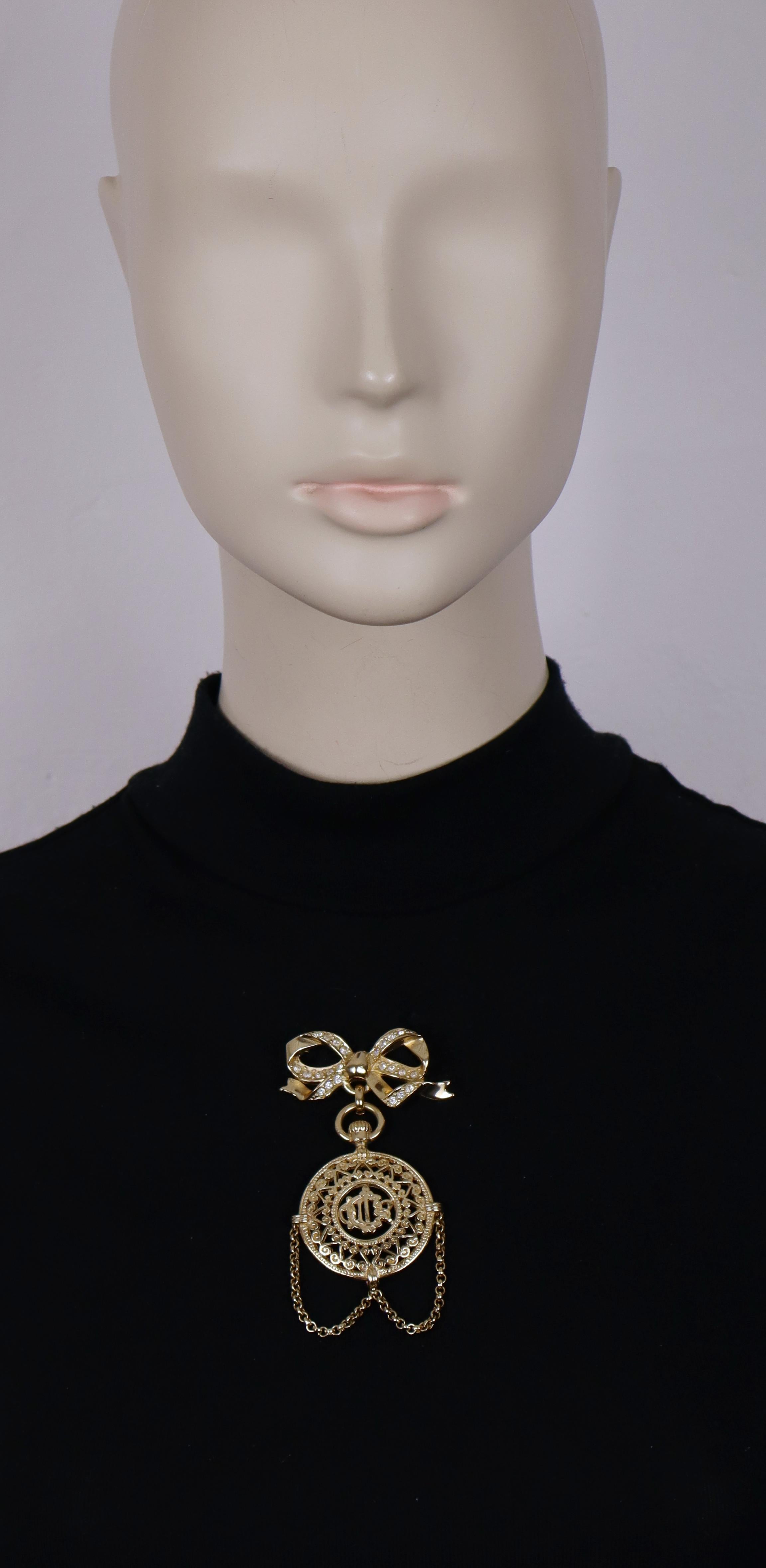 CHRISTIAN DIOR by GIANFRANCO FERRE vintage gold tone dangle brooch featuring a pocked watch design topped with a bow embellished with clear crystals, C DIOR intricate logo at the center.

Embossed CHRISTIAN DIOR BOUTIQUE.

Indicative measurements :