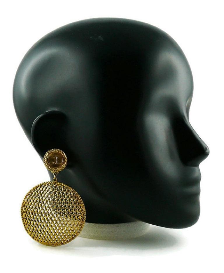 CHRISTIAN DIOR BOUTIQUE vintage gold toned dangling earrings (clip-on) featuring a massive disc with openwork woven design and CD monogram top.

GIANFRANCO FERRE era.

Marked CHRISTIAN DIOR BOUTIQUE.

Indicative measurements : height approx. 8.5 cm