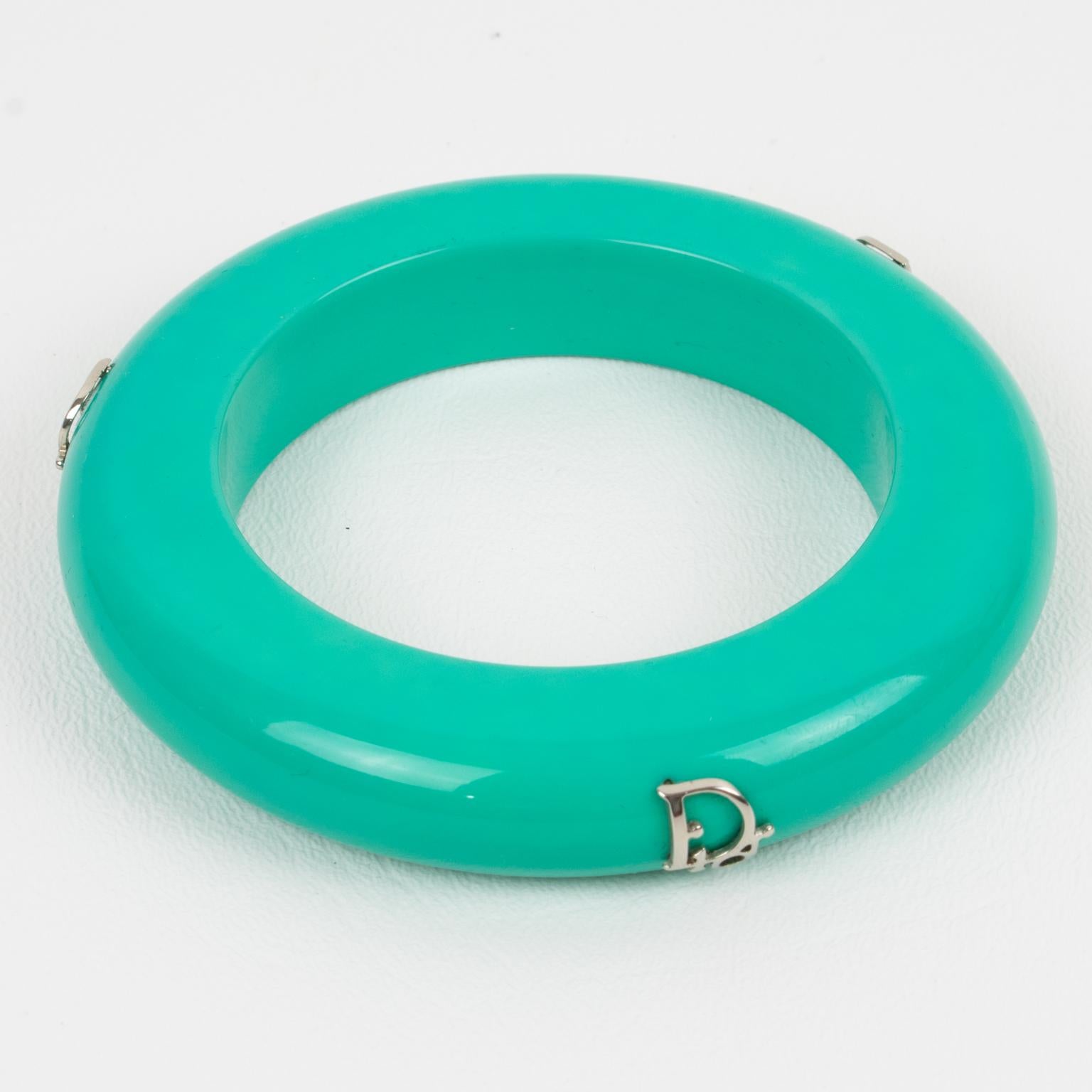 This exquisite Christian Dior bangle bracelet features a stunning turquoise hue and three striking silver 
