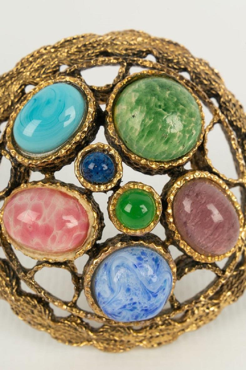 Dior- (Made in Germany) Brooch in gilded metal and glass paste. Collection 1970.

Additional information:
Dimensions: Ø 5.5 cm
Condition: Very good condition
Seller Ref number: BR127