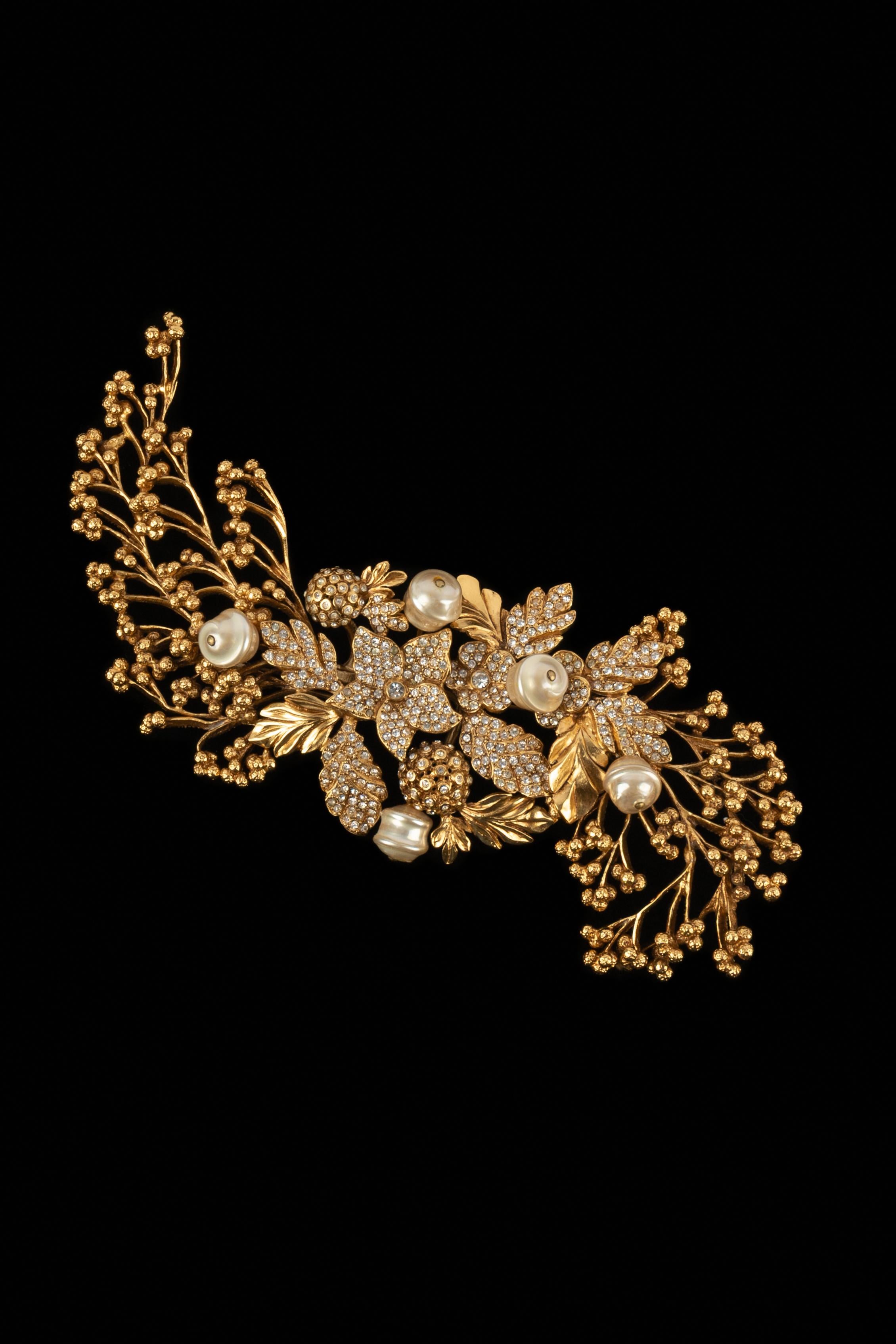 DIOR - Beeindruckende Brosche aus goldenem Metall in Form von Blüten und Blättern, verziert mit Strasssteinen und Trachtenperlen. Frühjahr-Sommer-Kollektion 1993, unter der künstlerischen Leitung von Gianfranco Ferré.

Bedingung:
Sehr guter