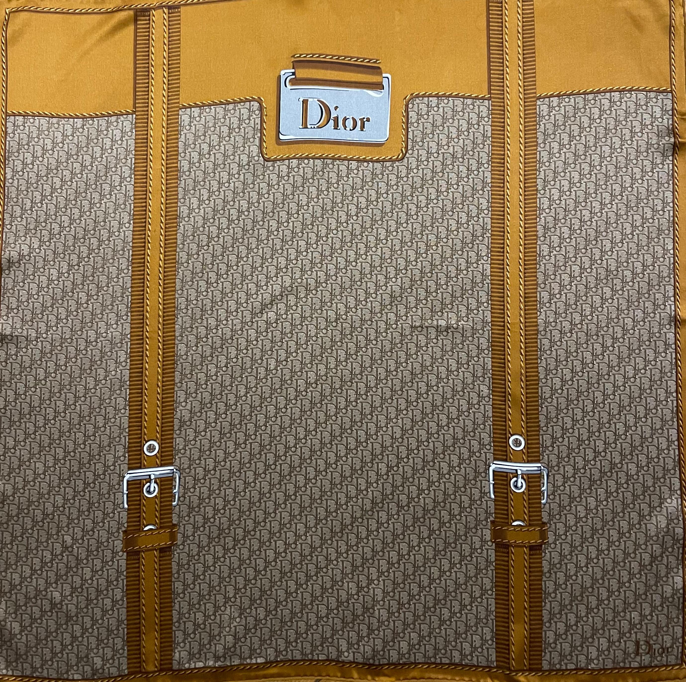 Foulard en soie marron et Monogram de Christian Dior. Magnifique écharpe représentant la valise la plus célèbre de la marque. Sa taille le rend pratique à porter et en fait un complément idéal à votre garde-robe. 
En bon état. 
26in x 26in. 