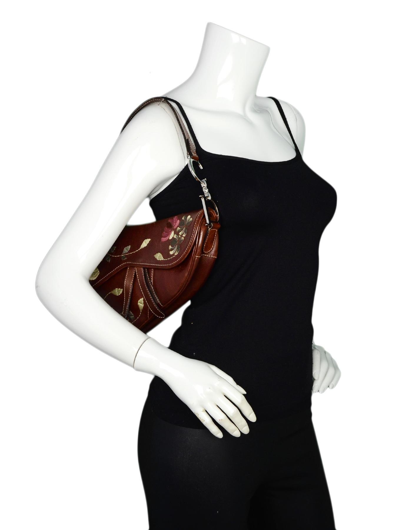 Christian Dior Brown Leather Embroidered Floral Saddle Bag 

Made In: Italy
Color: Brown, yellow, green
Hardware: Silvertone
Materials: Leather, metal, embroidery 
Lining: Brown/black Dior logo jacquard textile
Closure/Opening: Flap top with velcro