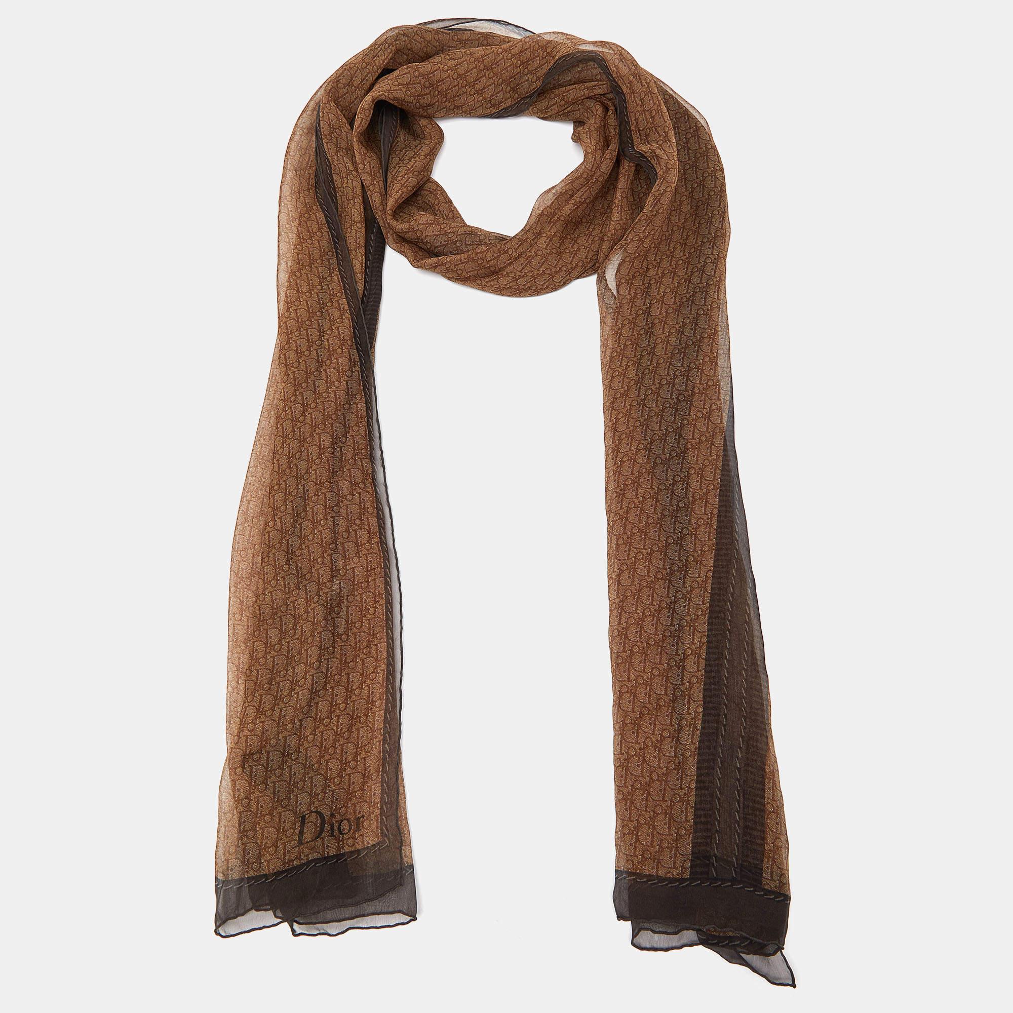 The Christian Dior stole is a luxurious fashion accessory. Crafted from high-quality silk, it features the iconic Dior Oblique logo pattern in a soft brown hue. This lightweight, generously sized stole is perfect for adding elegance and