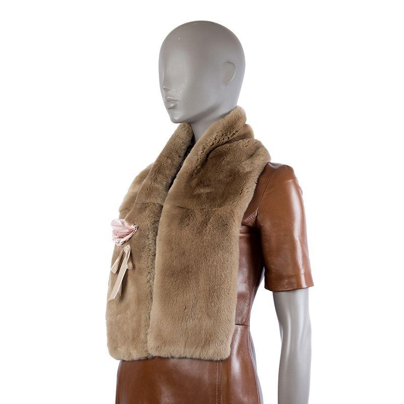 Christian Dior shawl in light-brown rabbit fur. Lined in off-white and light-brown Dior logo print silk. Has light-pink flower detail with a velvet bow attached. Has been worn and is in excellent condition.

Width 16cm (6.2in)
Length 119cm (46.4in)

