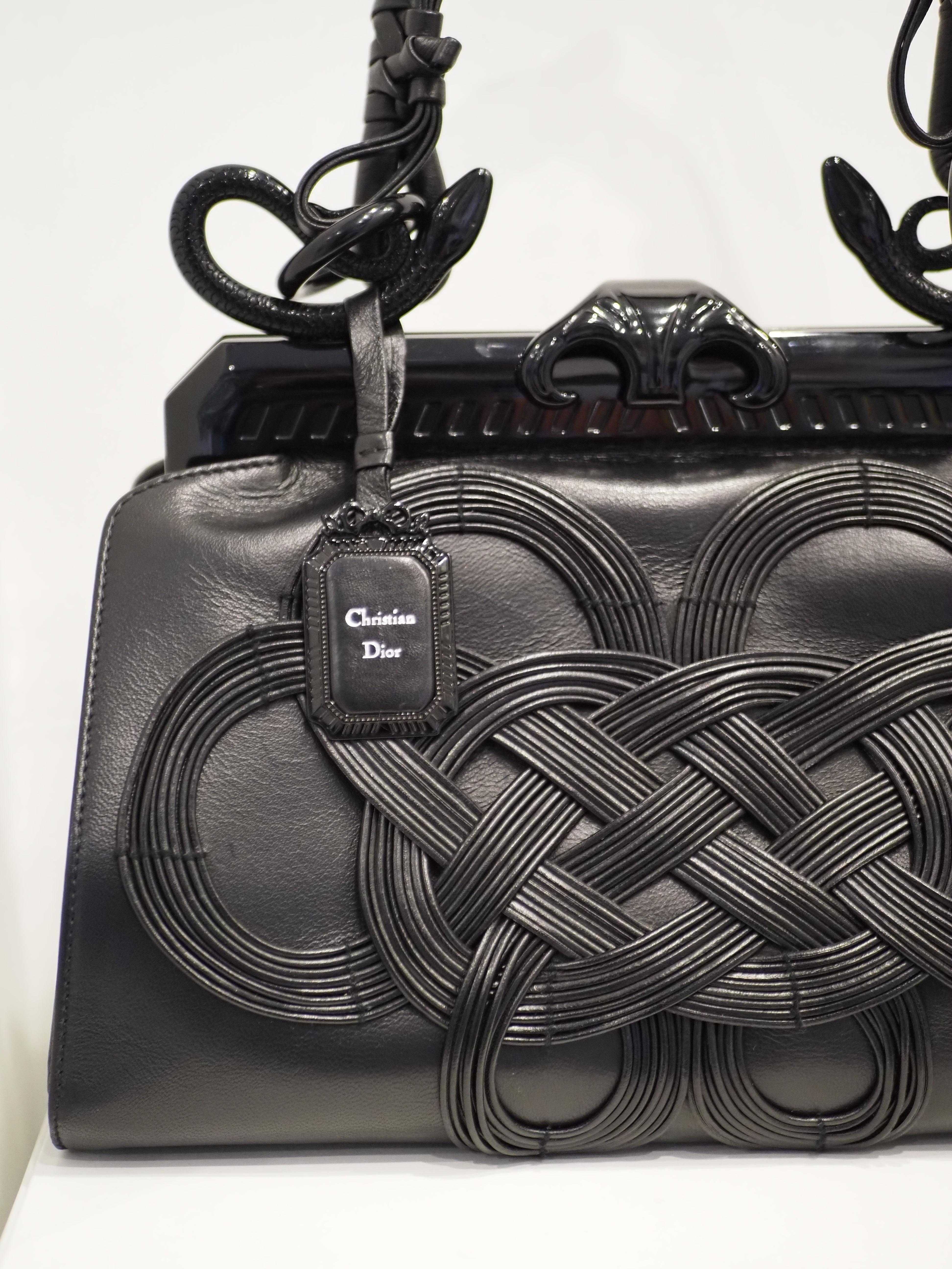 Christian Dior by Galliano Lim Ed Samourai black leather handle bag NWOT
Exterior
Samourai bag was designed for the 60 anniversary of Dior by Galliano
Smooth black leather
Japanese knot design at front
Multiple knots throughout handle
Push clasp